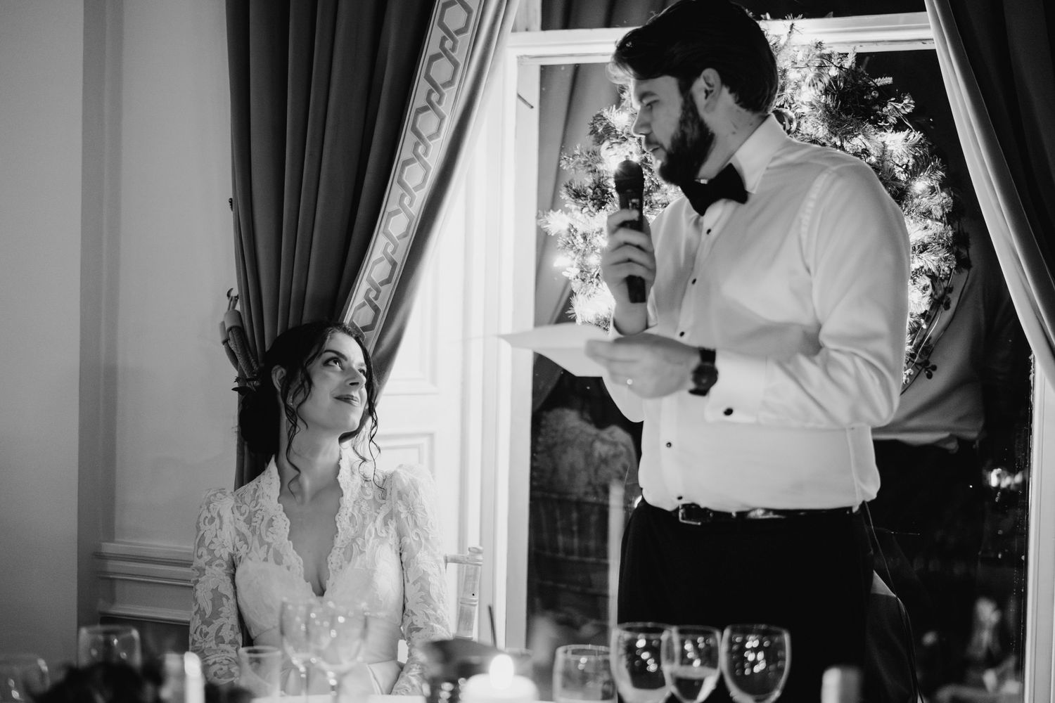 An elegant wedding ceremony in a room with dark curtains and soft lighting. Stephens green club dublin Wedding photographer