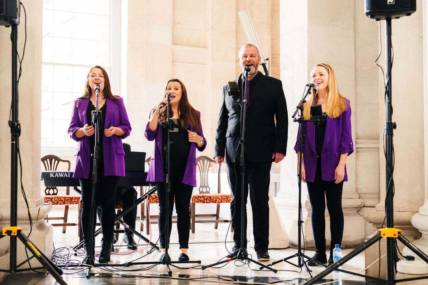 Choir performers in purple robes sing during an indoor performance at an elegant venue.  city hall dublin wedding photos