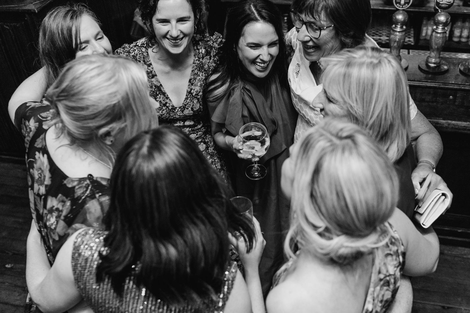 A group of people enjoying themselves and laughing together in a black and white candid moment. Wedding PHOTOGRAPHER Dublin