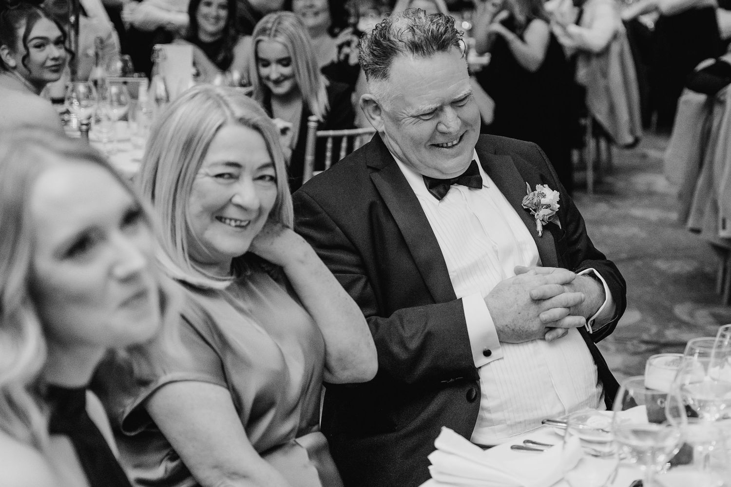 Black and white candid reception photos capturing joyful laughter among wedding guests. Wedding photographer dublin