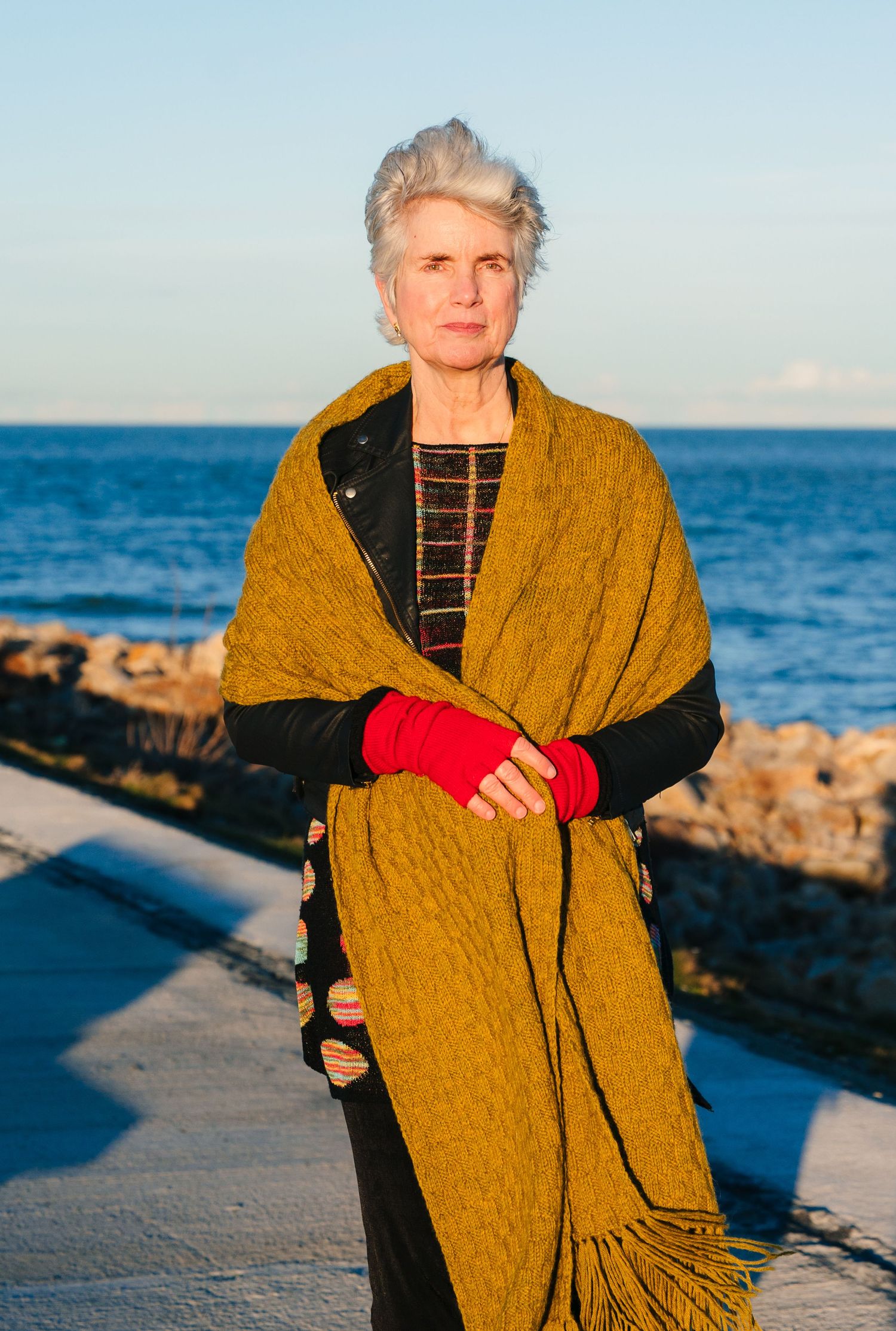 Seaside portraits with someone wearing a yellow shawl against blue ocean background. professional headshots branding photographer dublin ire