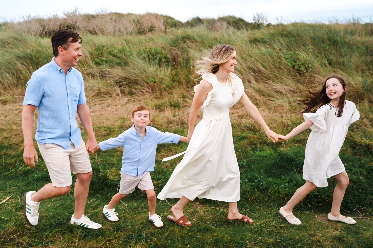 Series of candid jumping and running shots along a coastal path.  Family photographer Dublin Ireland\