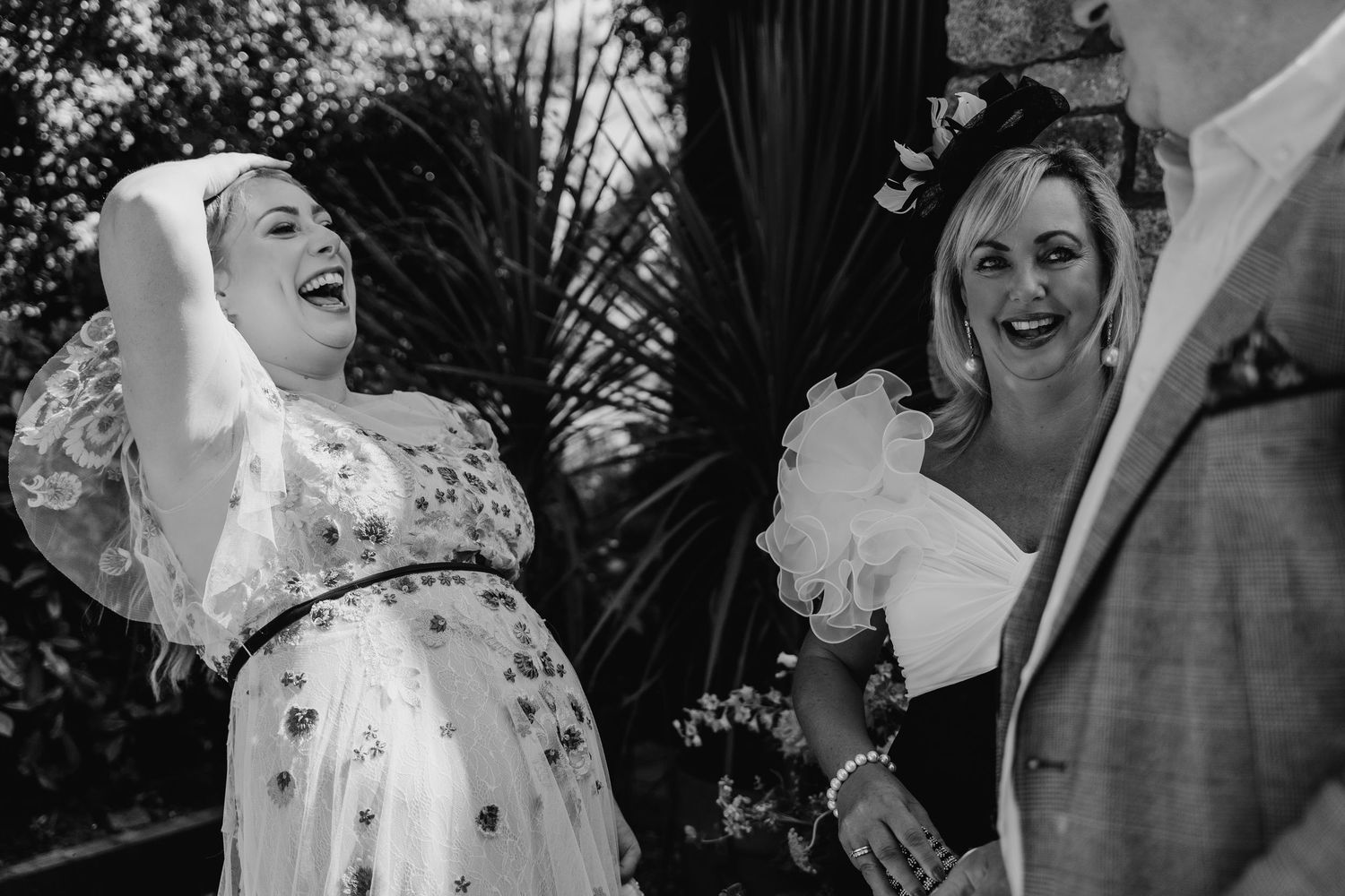 Black and white candid shot capturing genuine laughter and happiness during a wedding celebration. . Village Barn Tyrrellspass wedding photo