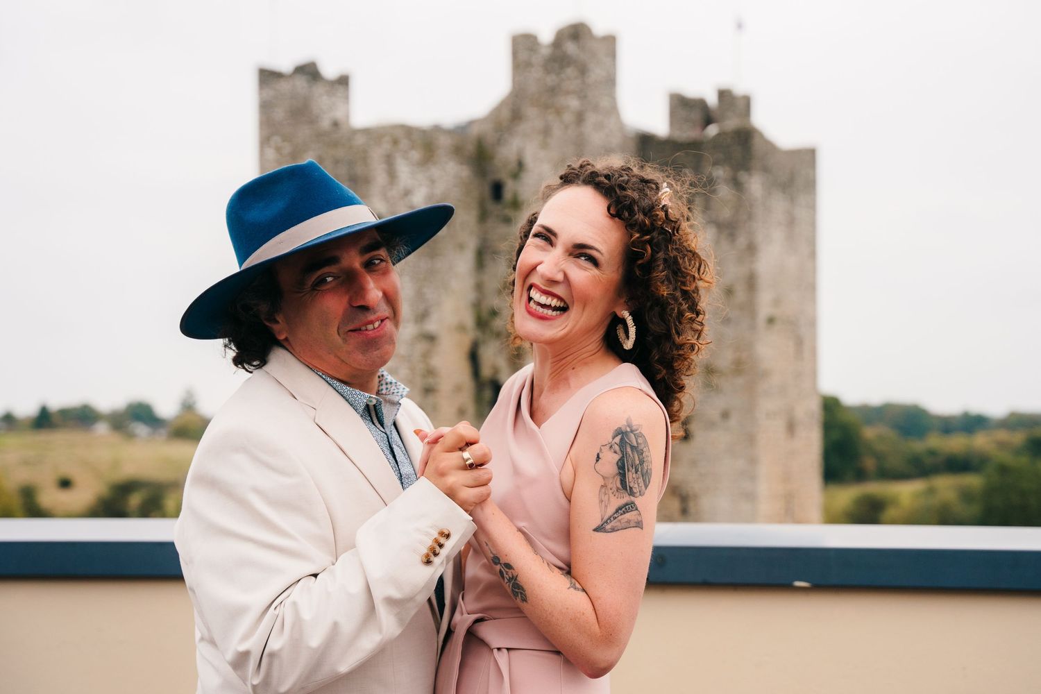 Couple laughing together near historic castle ruins on sunny day.Wedding Photography Trim Castle Ireland