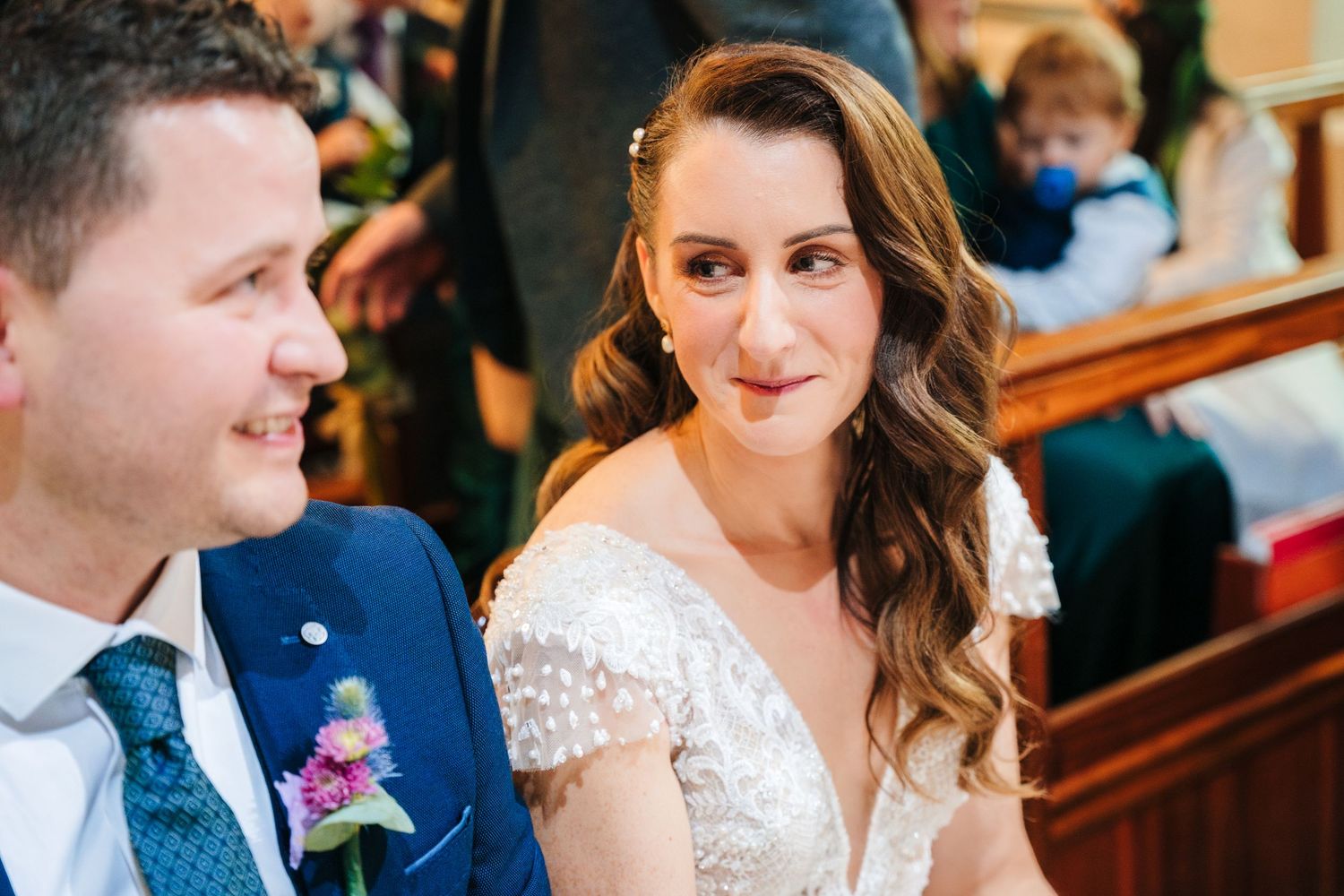 Wedding couple shares joyful moments with guests in a church setting.
