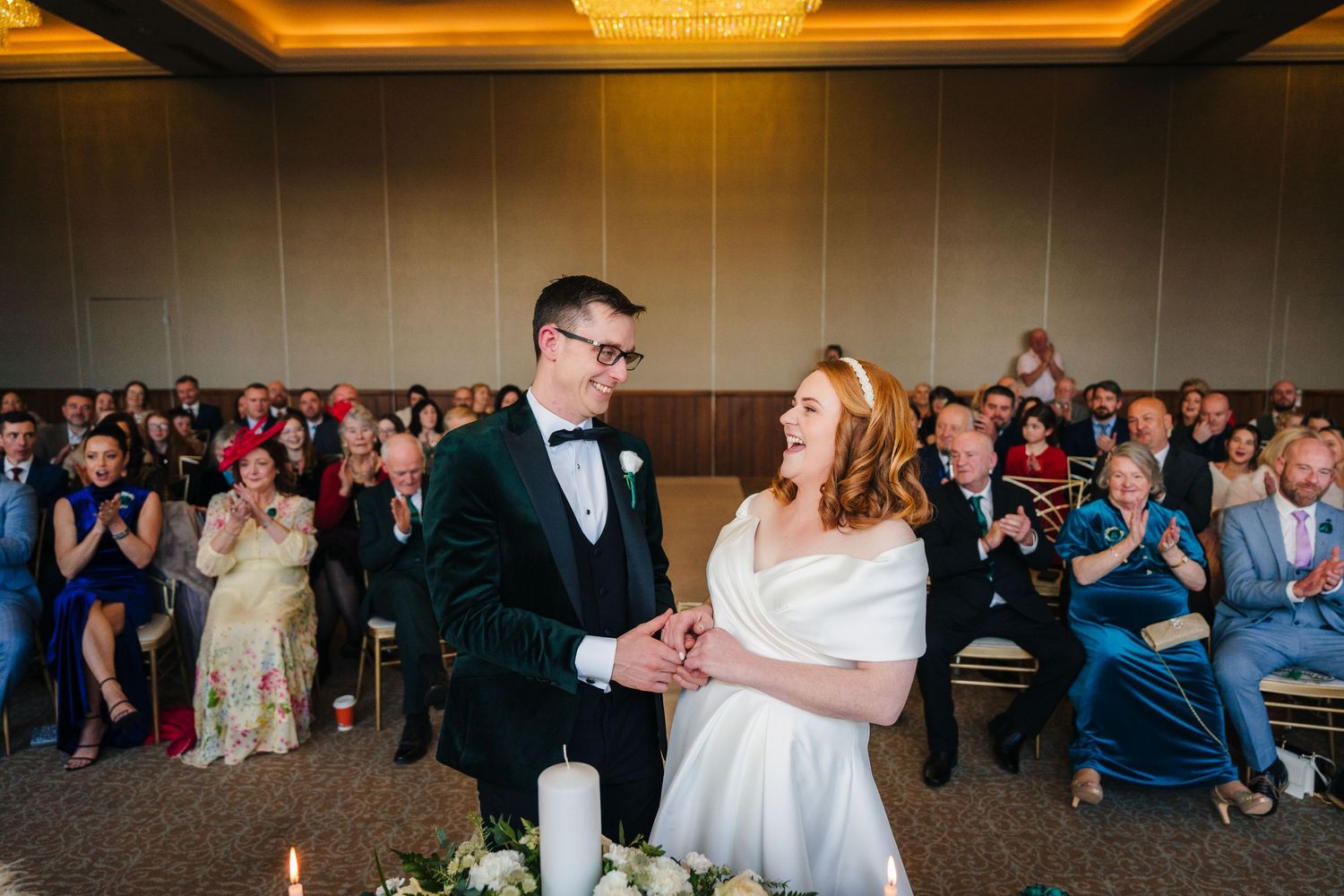 Wedding guests dance and celebrate on a dance floor during an evening reception celebration. Wedding PHOTOGRAPHER Dublin