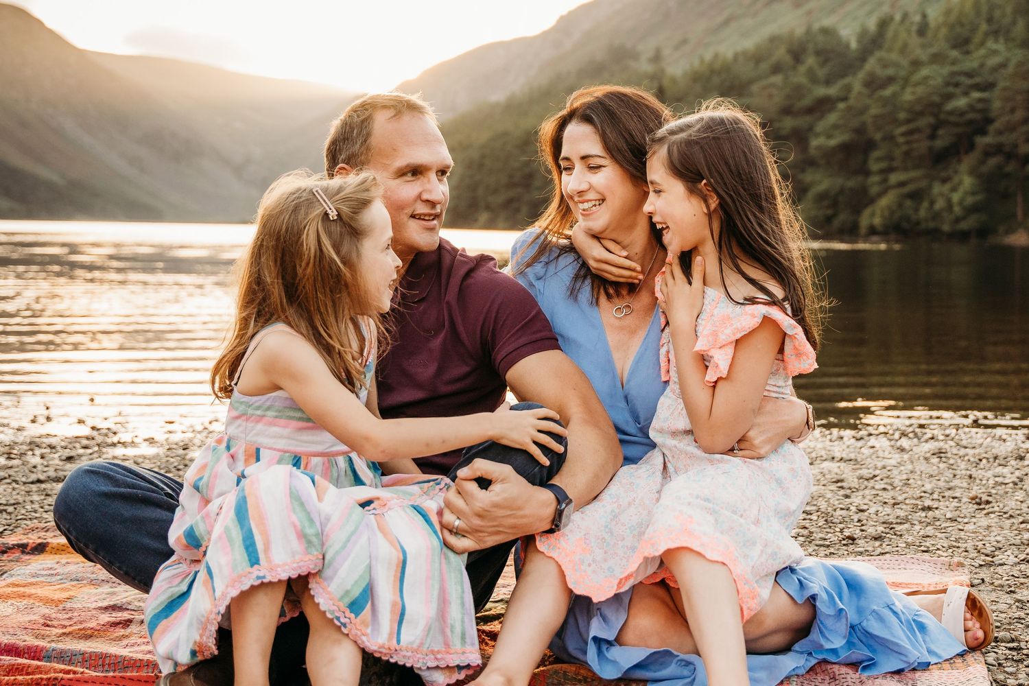 A loving family enjoys quality time together outdoors near a peaceful lake during golden hour sunset. family PHOTOGRAPHER Dublin