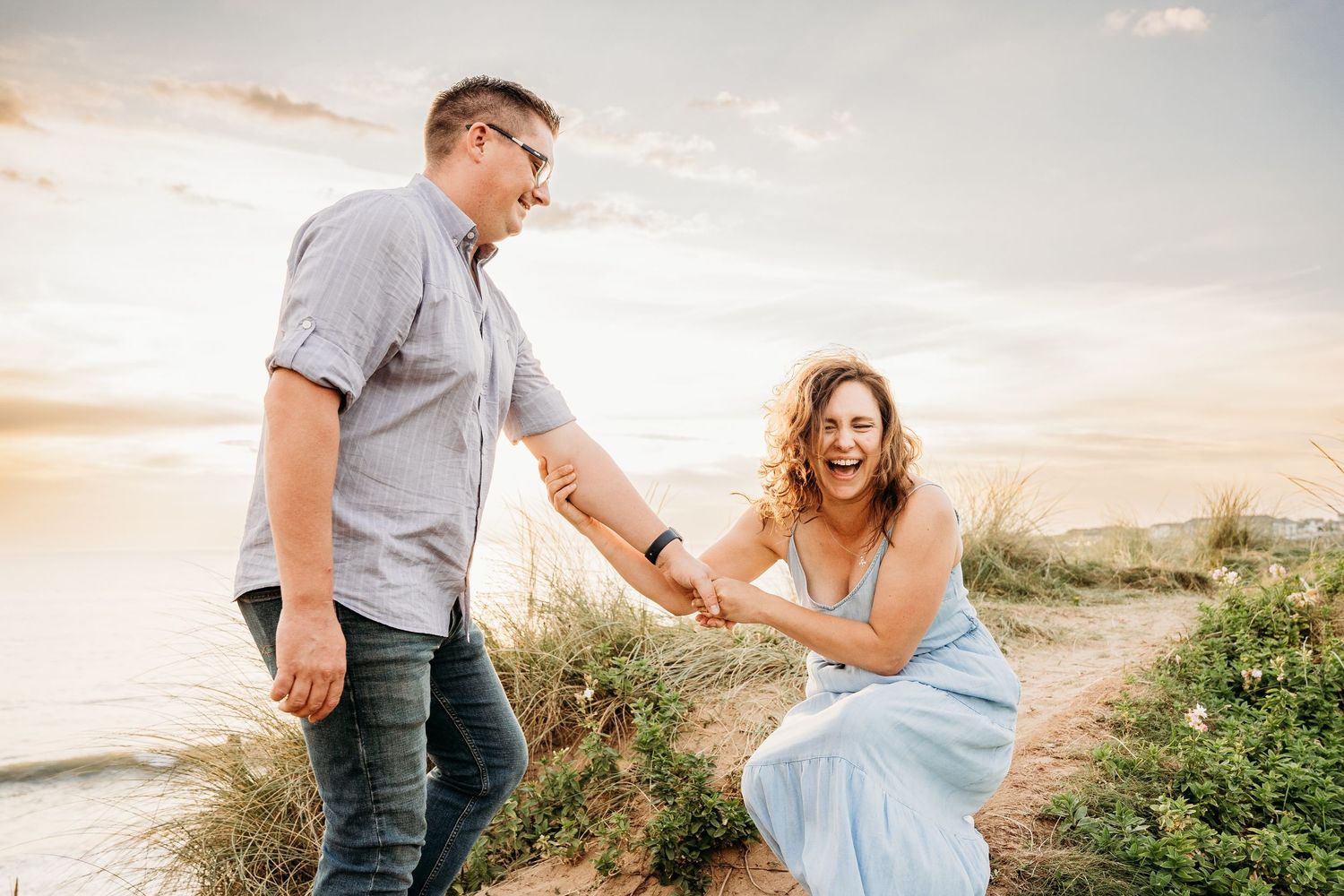 A couple shares a joyful moment together on a coastal path during sunset. PHOTOGRAPHER Dublin ireland
