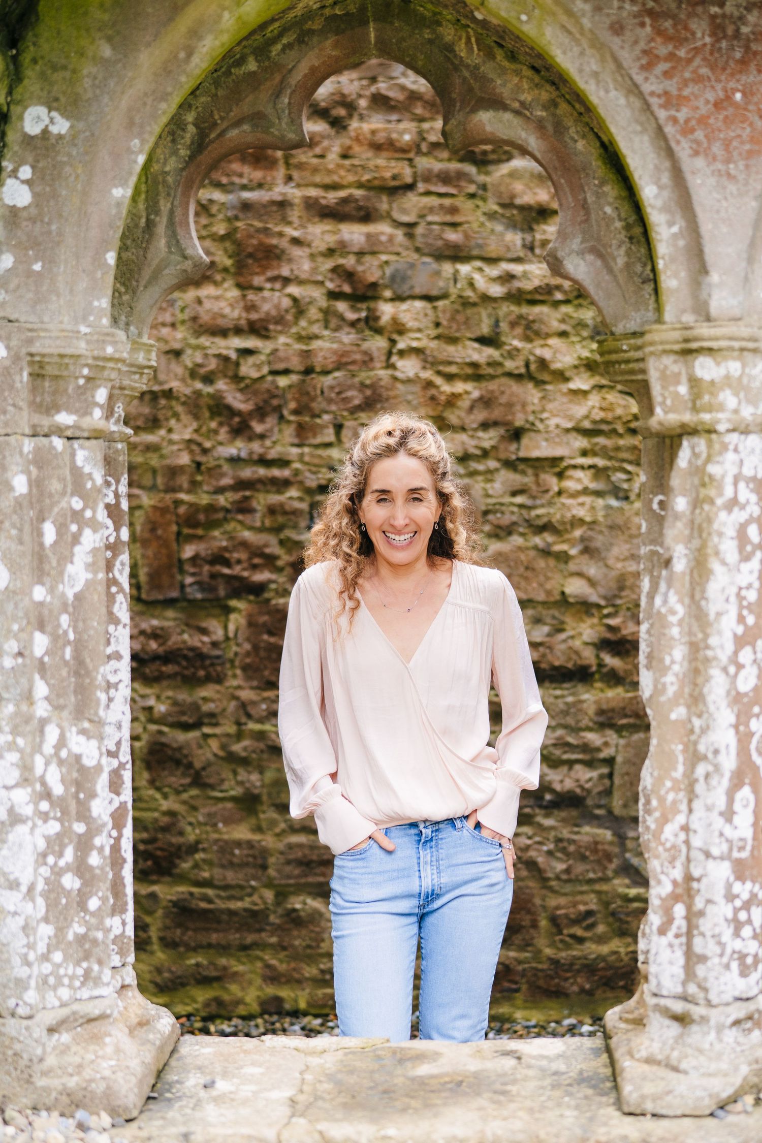 Stone archways frame a rustic architectural scene with weathered columns and walls. BEctive abbey family photographer dublin