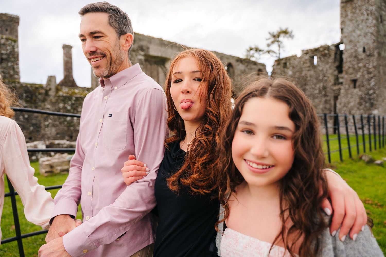 Family portrait session outdoors against stone ruins backdrop. BEctive abbey family photographer dublin