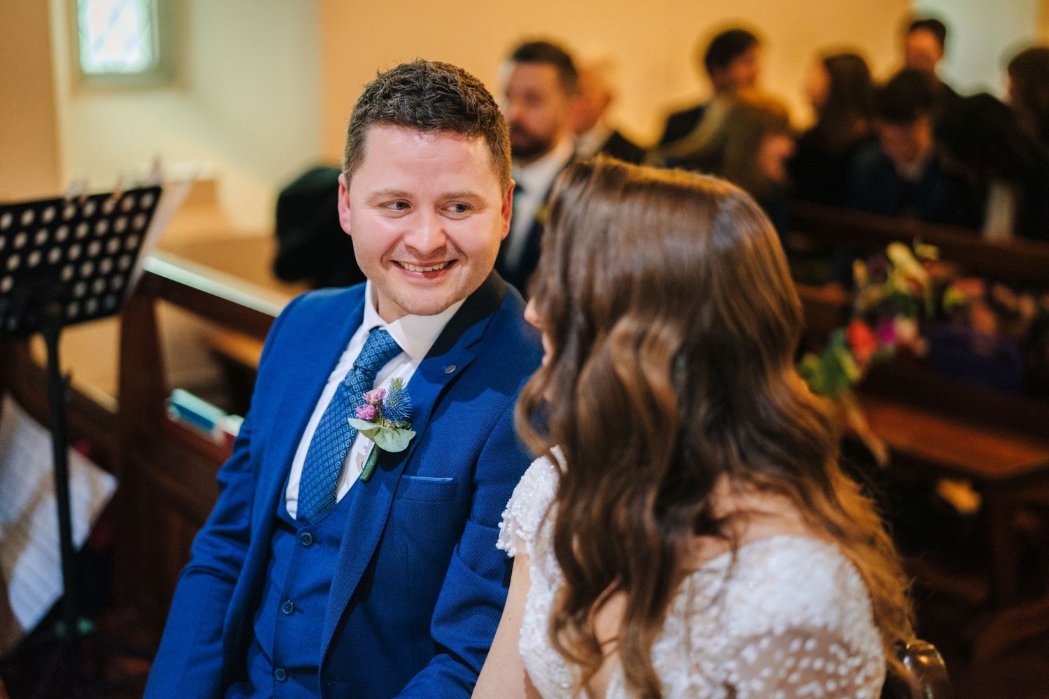 Wedding guests and family members share joyful moments during a church ceremony.