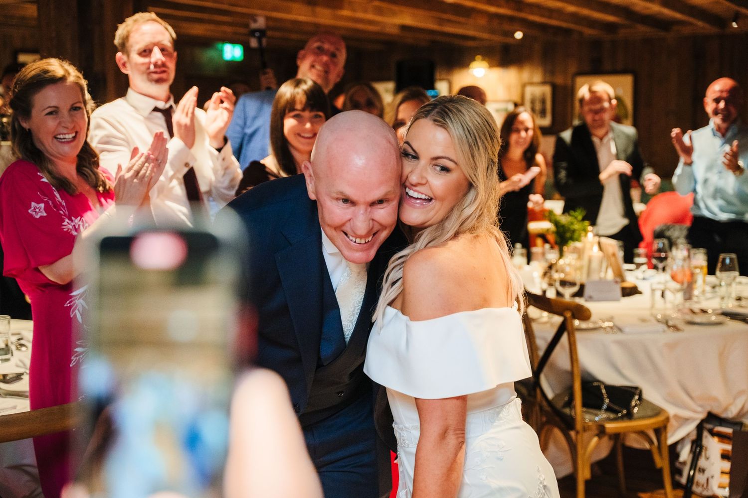 Wedding reception guests celebrate and dance in a warmly lit rustic venue. The Dean Dublin Wedding Photographer