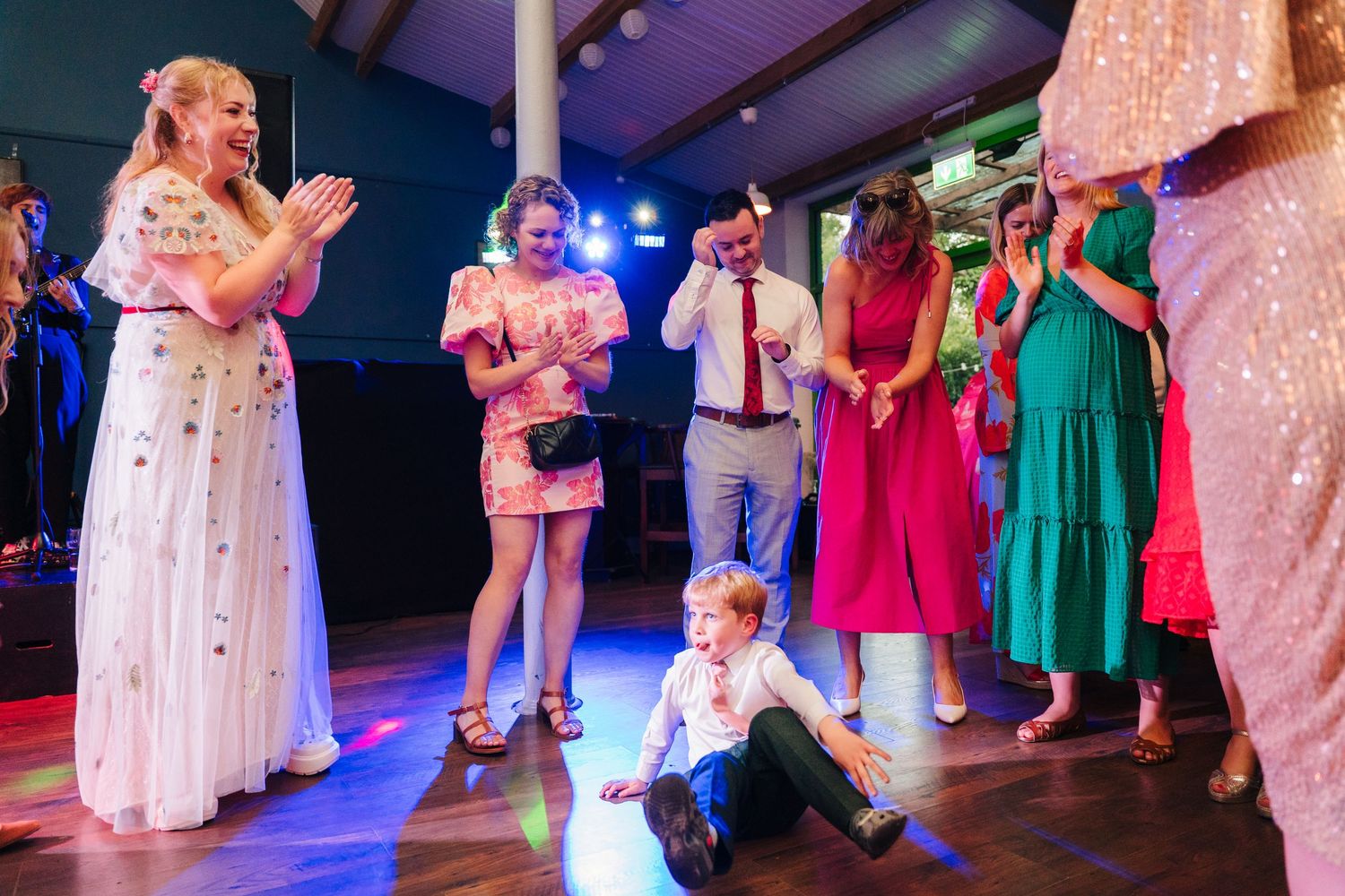 Wedding reception dance floor with colorful lighting and guests in formal attire. . Village Barn Tyrrellspass wedding photographer Ireland
