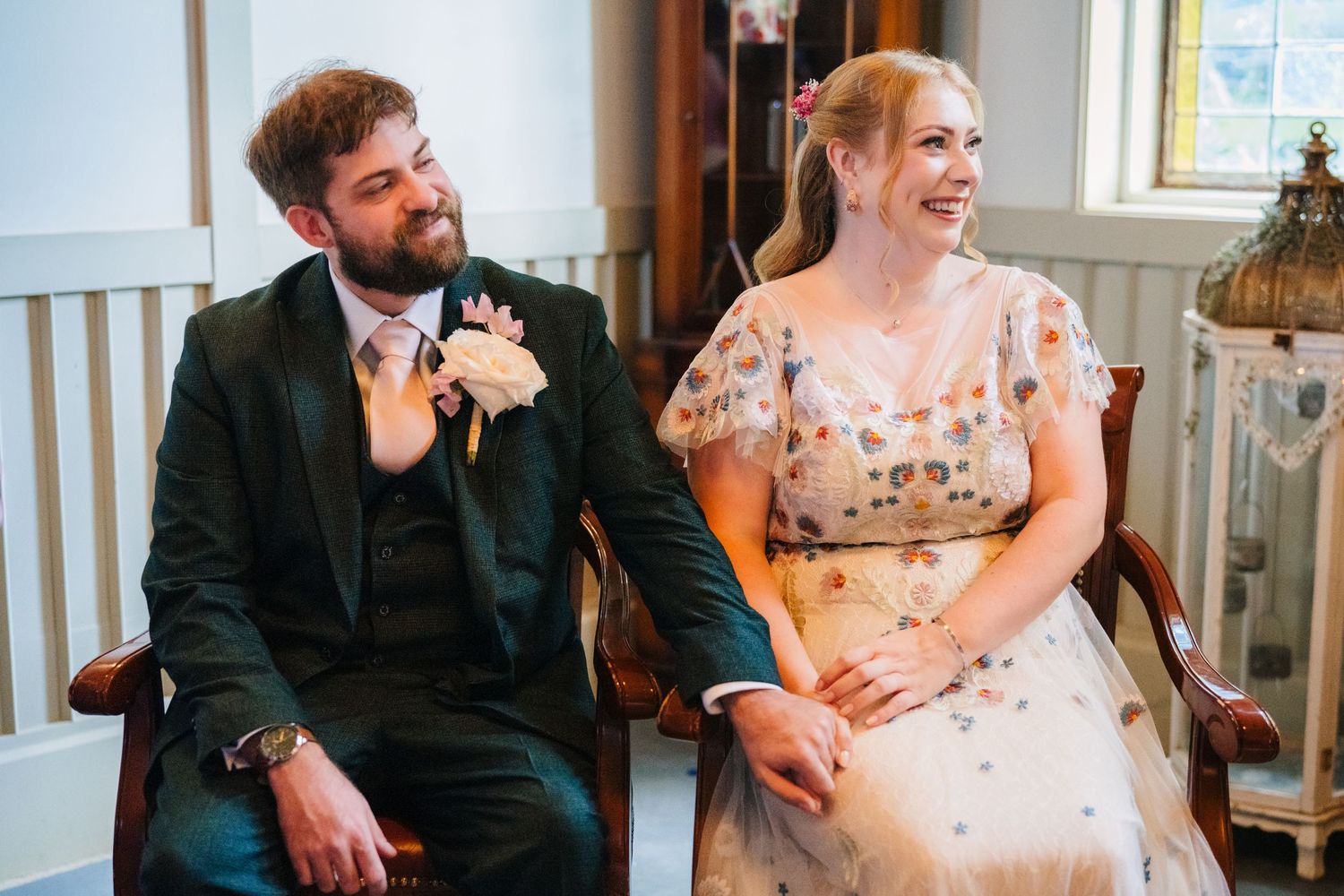 Wedding guests sharing joyful laughter during an indoor reception celebration. . Village Barn Tyrrellspass wedding photographer Ireland