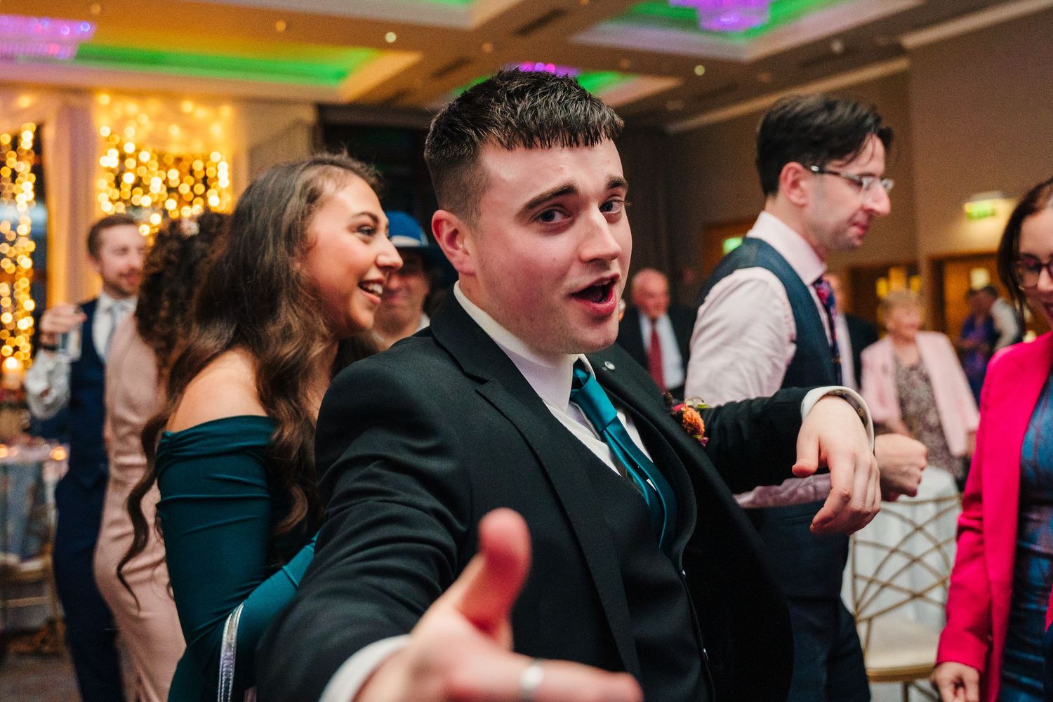Lively dance floor scene at wedding reception with colorful lighting and guests in formal attire.Wedding Photography Trim Castle Ireland