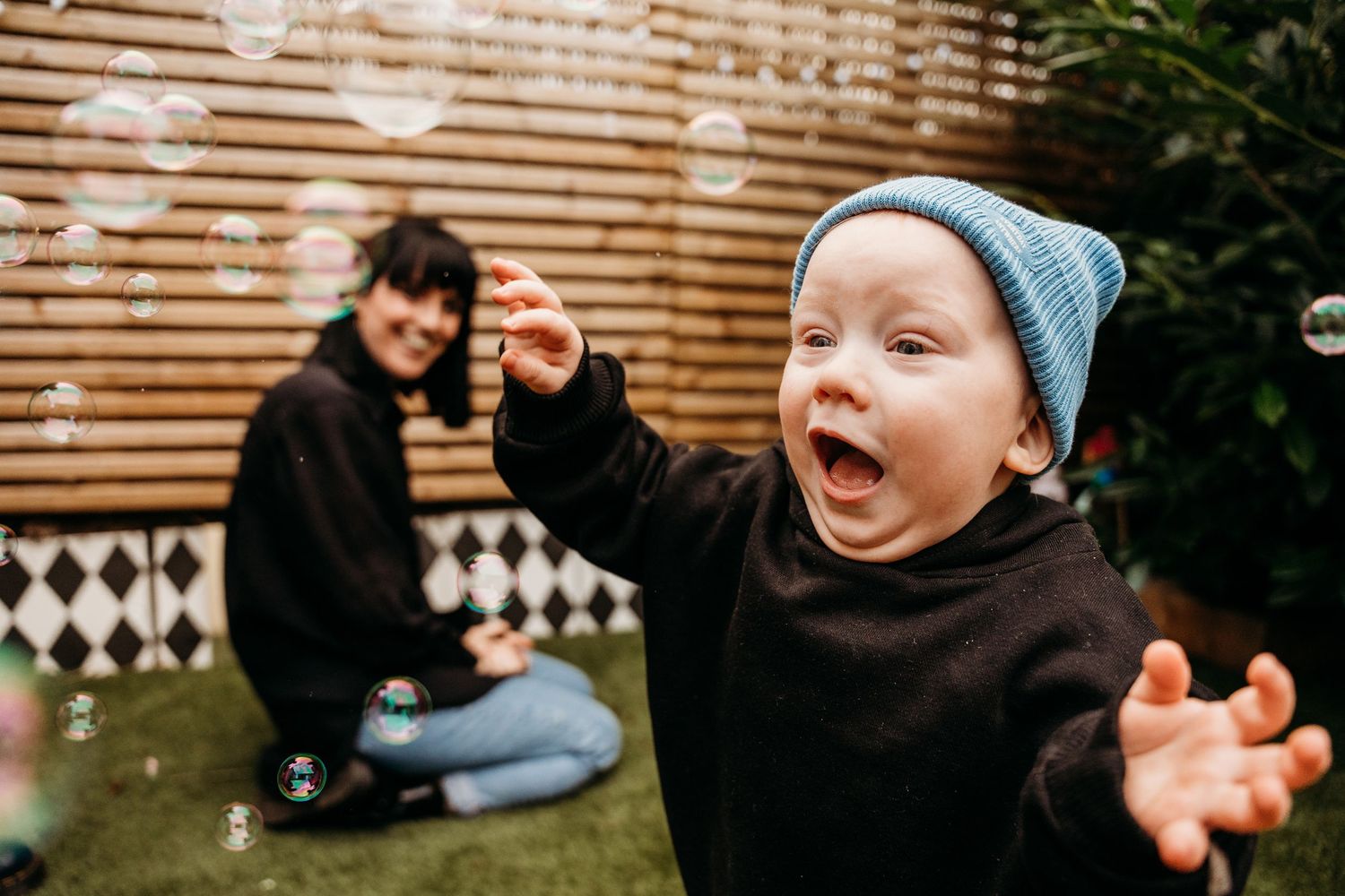 Joyful outdoor family photo session with bubbles and playful moments on a sunny day.  Family PHOTOGRAPHER Dublin