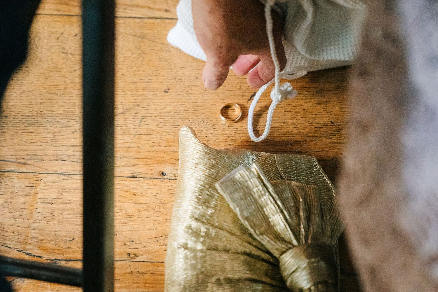 Close-up shot of hands tying ribbons and preparing wedding details on a rustic wooden surface. Same sex wedding PHOTOGRAPHER Dublin