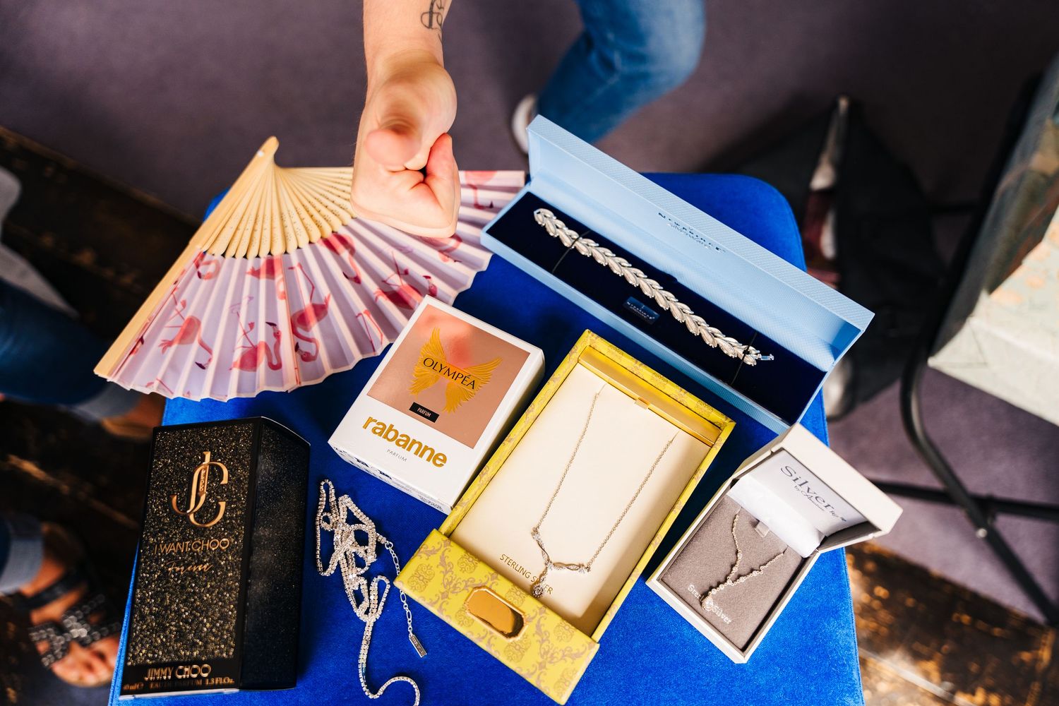 Display of wedding accessories including scattered cash, ornate fan, and small decorative boxes on a blue surface. House Dublin Wedding Phot