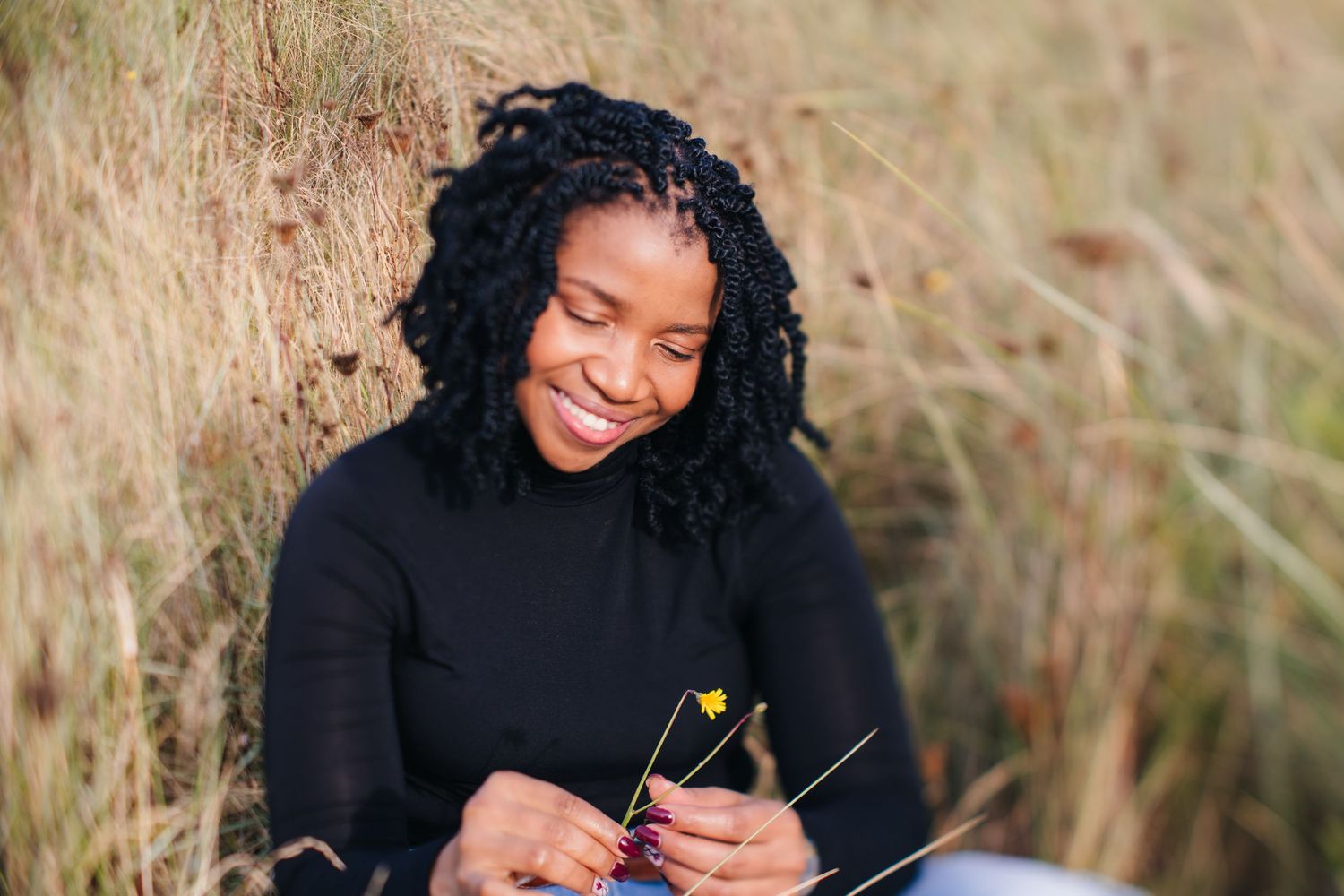 Candid moments captured in a field of tall grass wearing a black sweater. Dublin professional headshots photographer