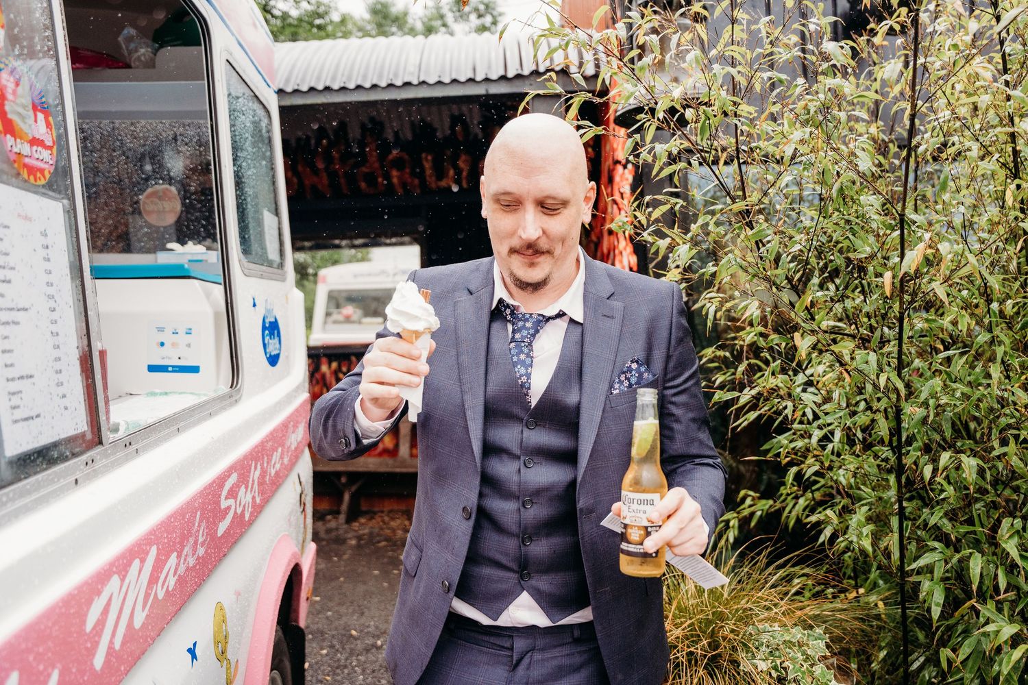 Guest in a navy suit enjoys ice cream from a food truck at a wedding reception. Wedding photographer Dublin