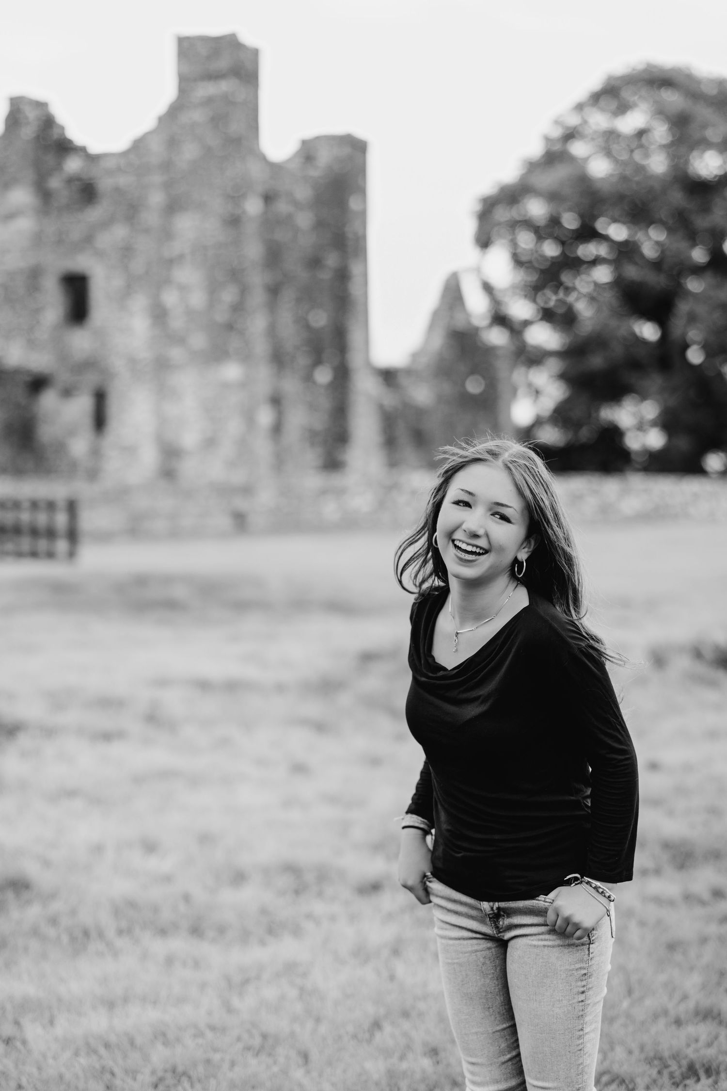 Black and white portrait series showing joyful expressions and movement against a historic stone building backdrop. BEctive abbey family pho