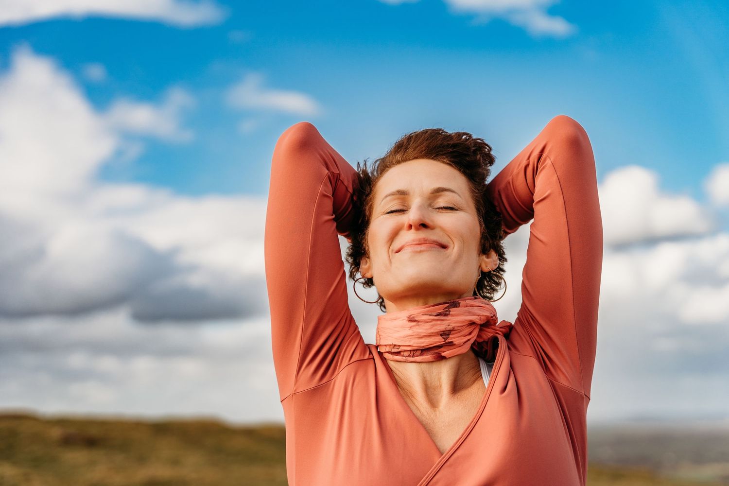 A collage of six photos showing someone in a peach-colored sweater stretching against a bright blue sky with clouds. Portrait PHOTOGRAPHER D