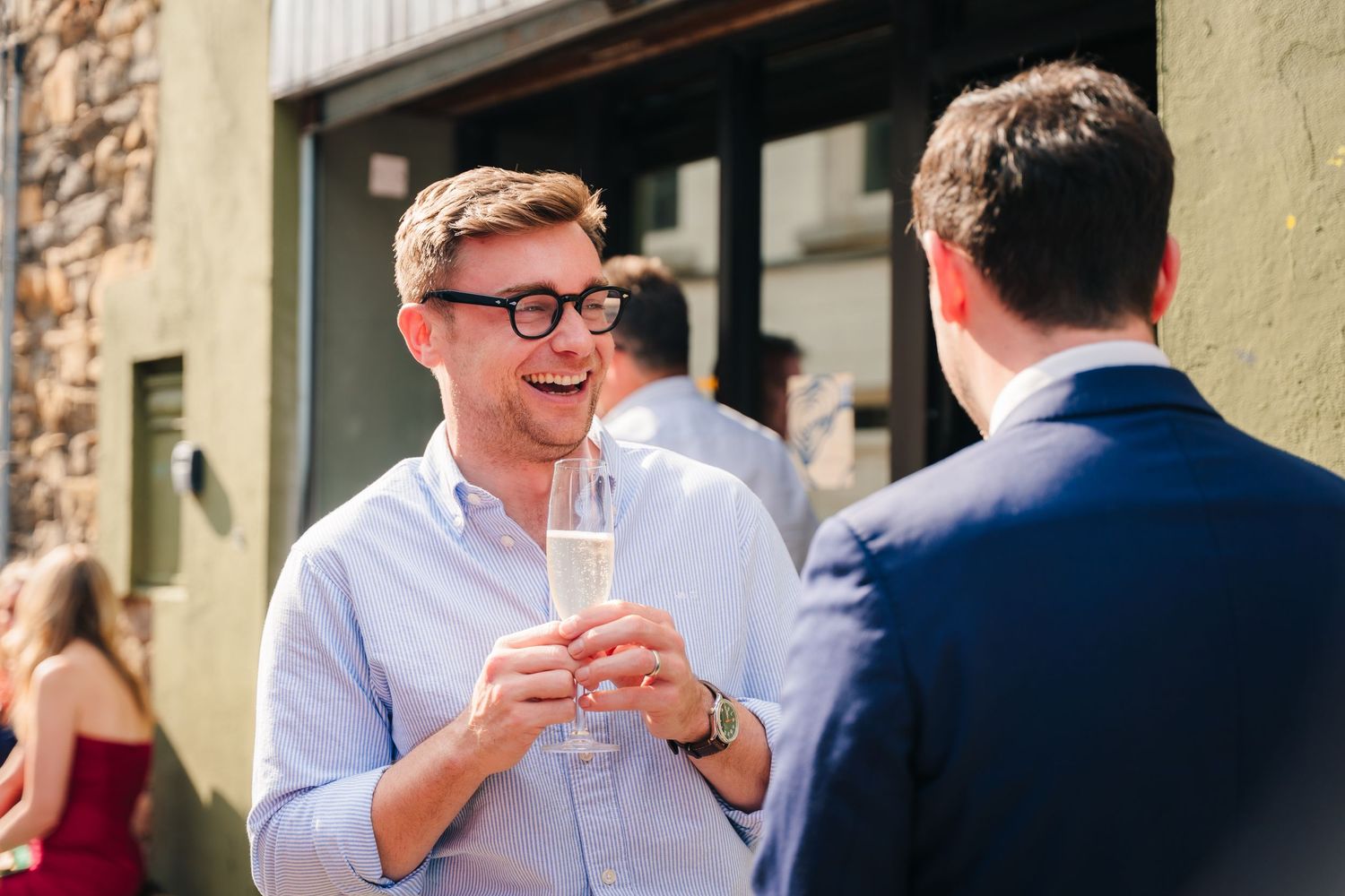 Wedding guests enjoying drinks and conversation during outdoor reception. Same sex wedding PHOTOGRAPHER Dublin
