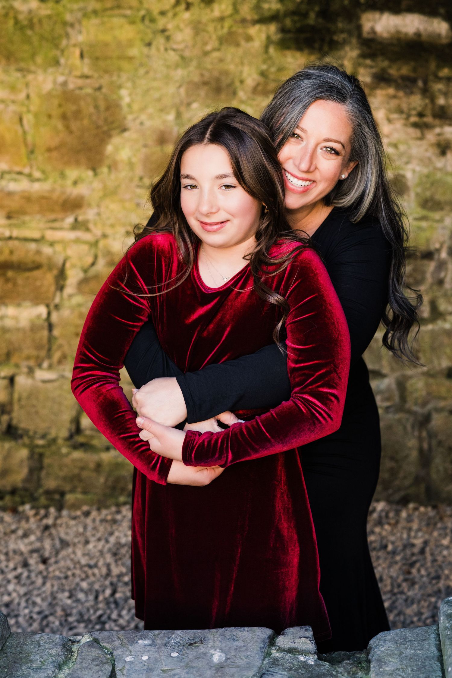 Portrait series showing warm embraces against rustic stone wall background. Family PHOTOGRAPHER Dublin