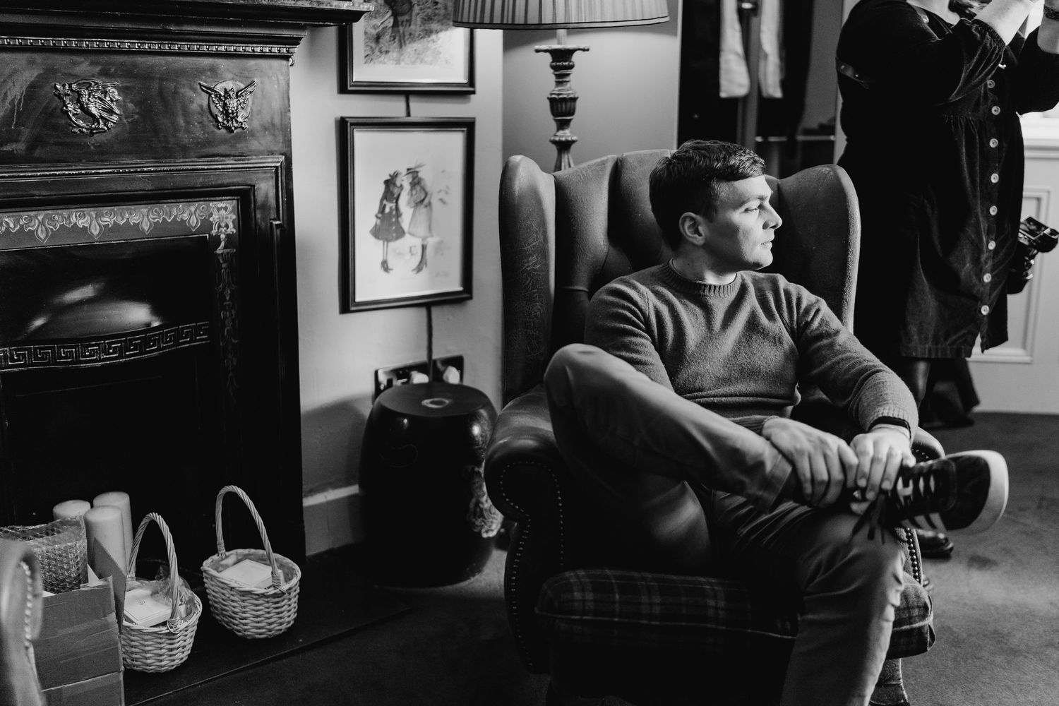 Castle Leslie Wedding Photographer A vintage black and white photograph showing someone sitting in an armchair next to an ornate fireplace.