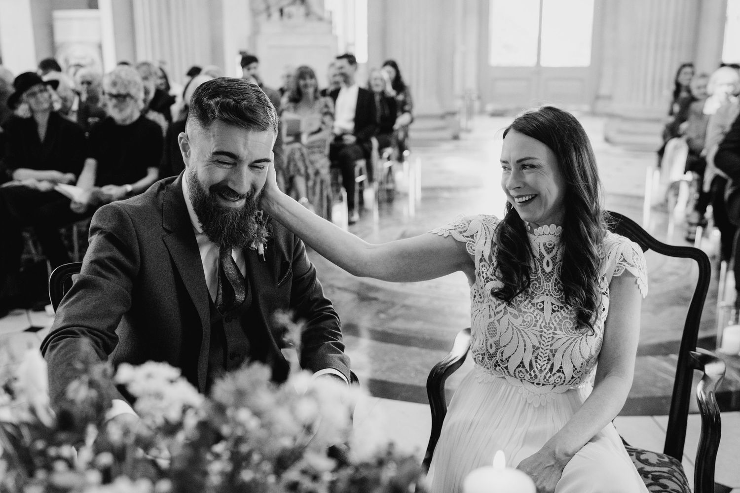 Wedding guests dance and celebrate at an elegant indoor reception venue with soft lighting and decorative details. wedding photographer dubl