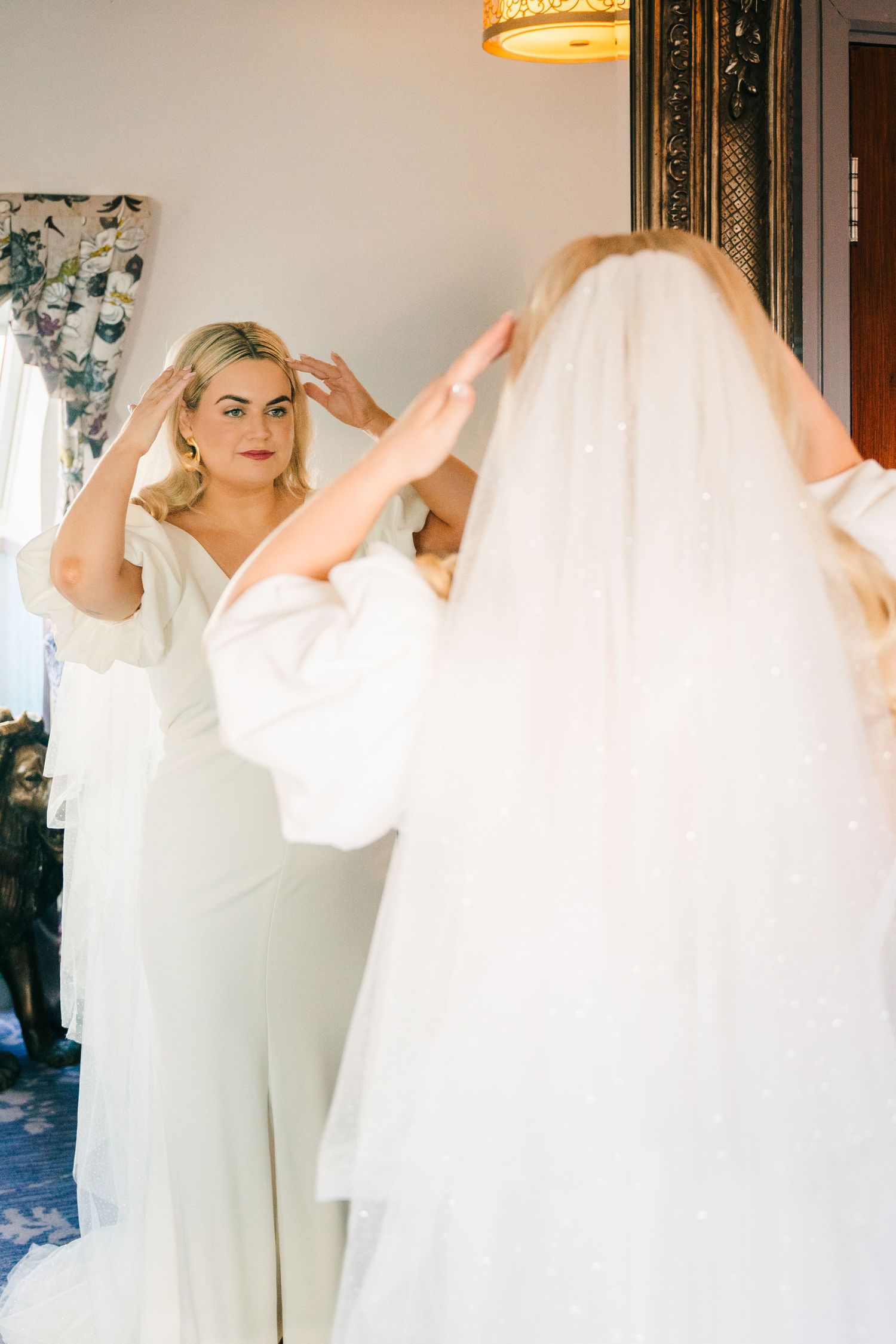 Elegant bridal preparation scene with flowing white fabric and soft lighting in a luxurious dressing room. Wedding photographer dublin