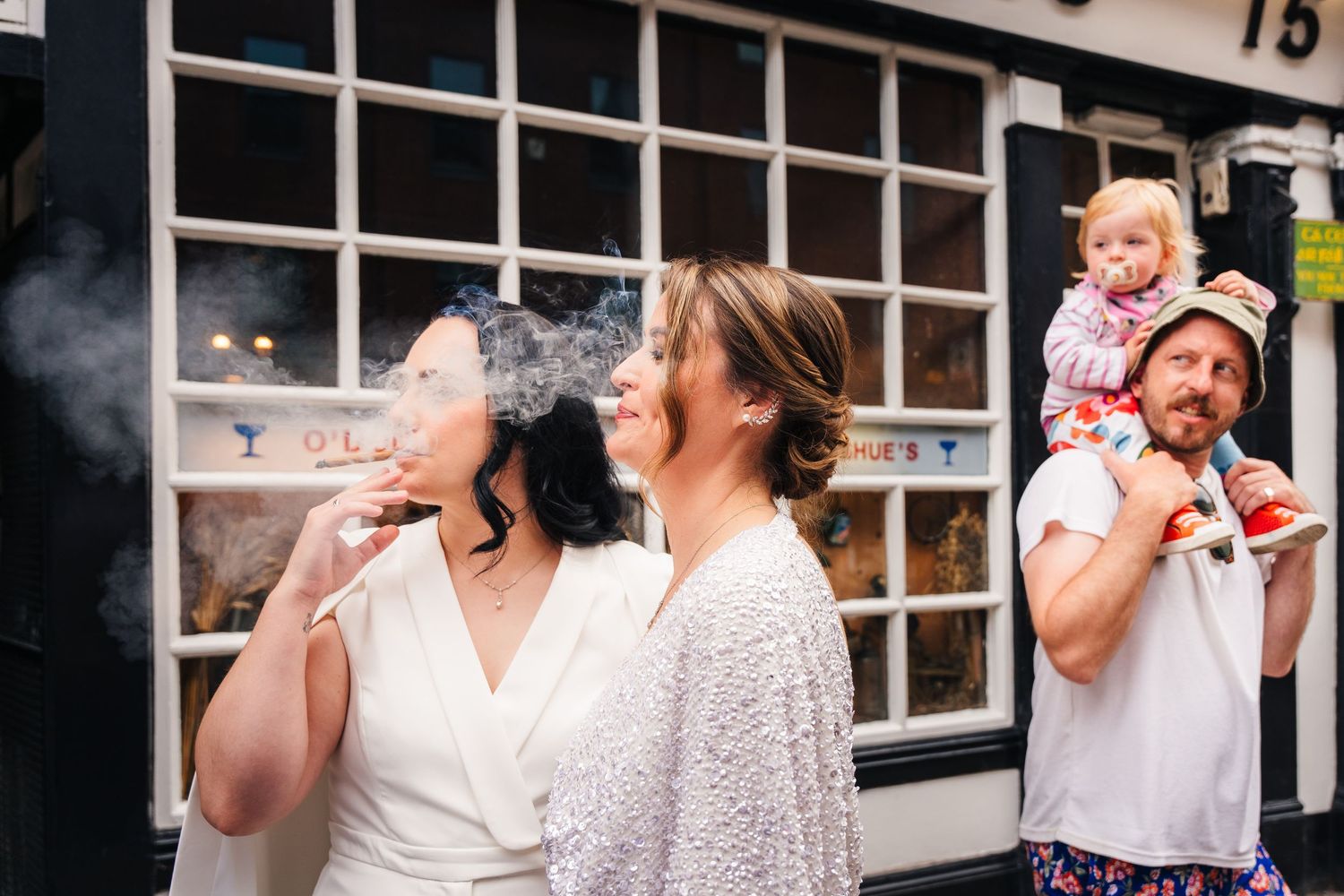 A sequence of five partying people in white outfits smiling and toasting with drinks at an outdoor event. Wedding PHOTOGRAPHER Dublin