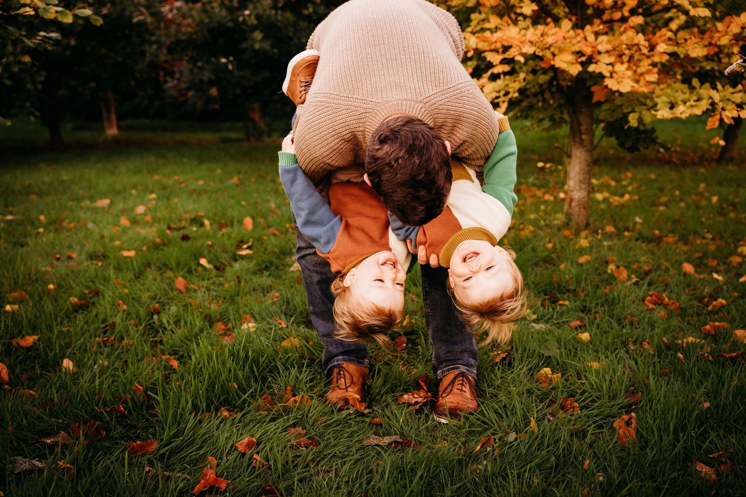 A series of seasonal photographs showing hands collecting fallen autumn leaves and acorns from green grass. family PHOTOGRAPHER Dublin
