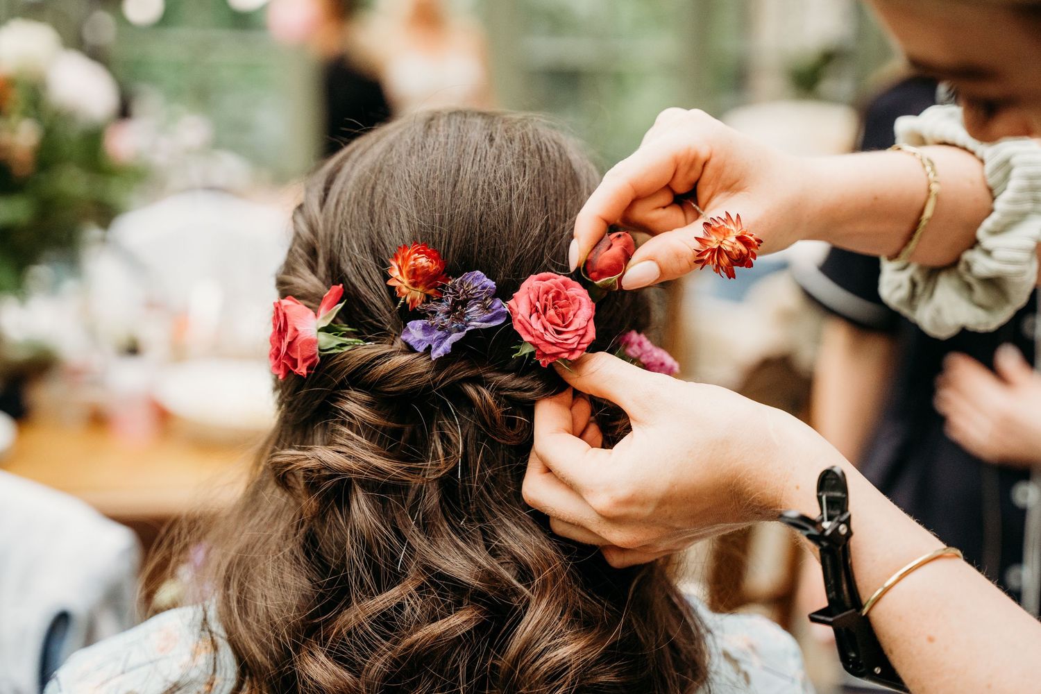 Close-up shot of someone having flowers placed in their braided hairstyle. Wedding photographer Dublin