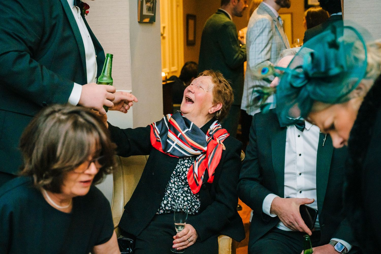 Guests enjoying drinks and laughter at an indoor wedding celebration. Stephens green club dublin Wedding photographer