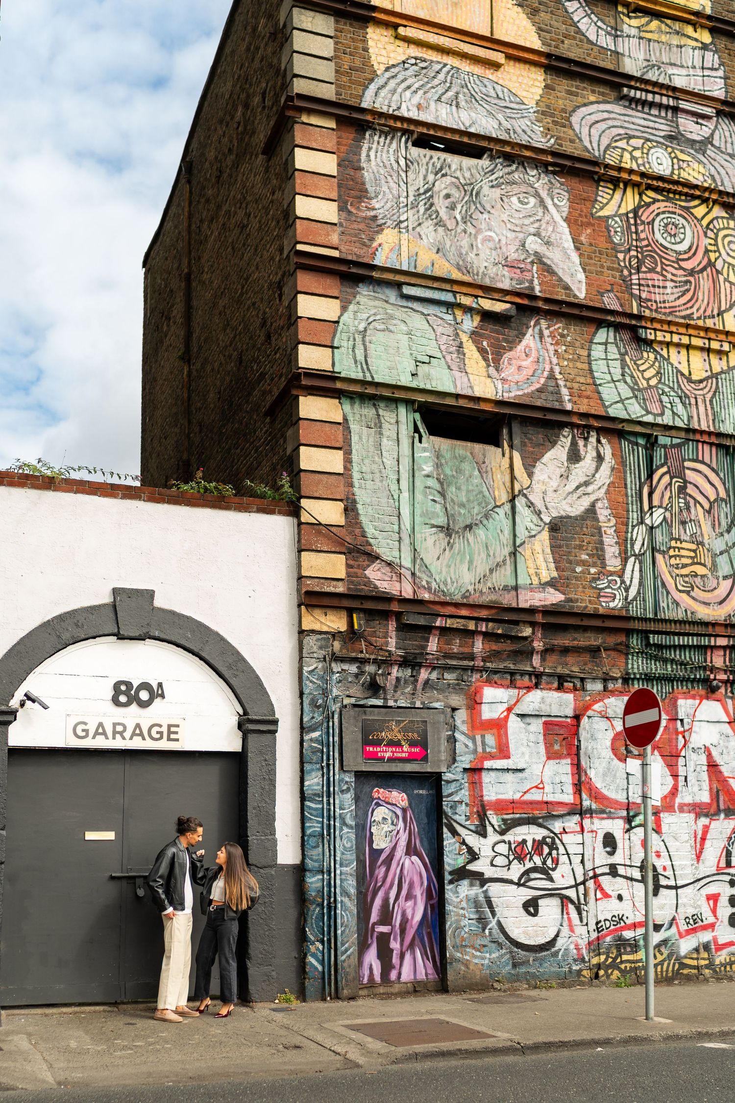 Colorful graffiti art adorns the walls of an urban garage entrance. Couple's Photoshoot PHOTOGRAPHER Dublin