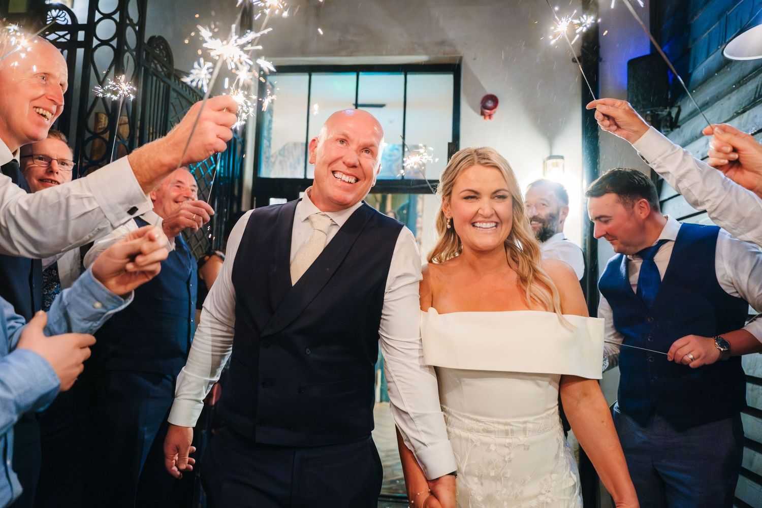 A joyful wedding celebration with guests dancing and celebrating at an indoor reception venue. The Dean Dublin Wedding Photographer