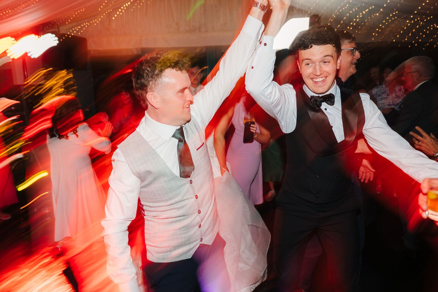 Virginia Park Lodge Wedding photographer Dublin Ireland Meath Dance floor filled with wedding guests celebrating under red lighting effects.