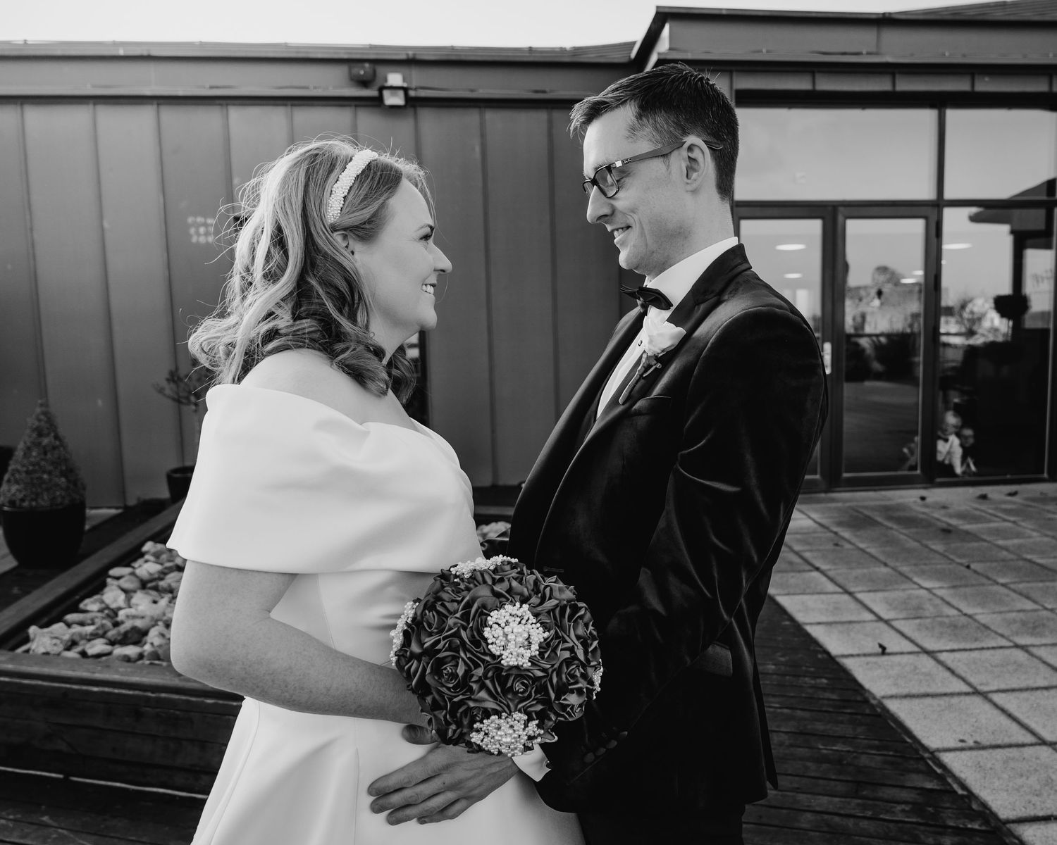 Black and white photos show romantic moments on an outdoor terrace with city views.  Wedding PHOTOGRAPHER Trim Castle