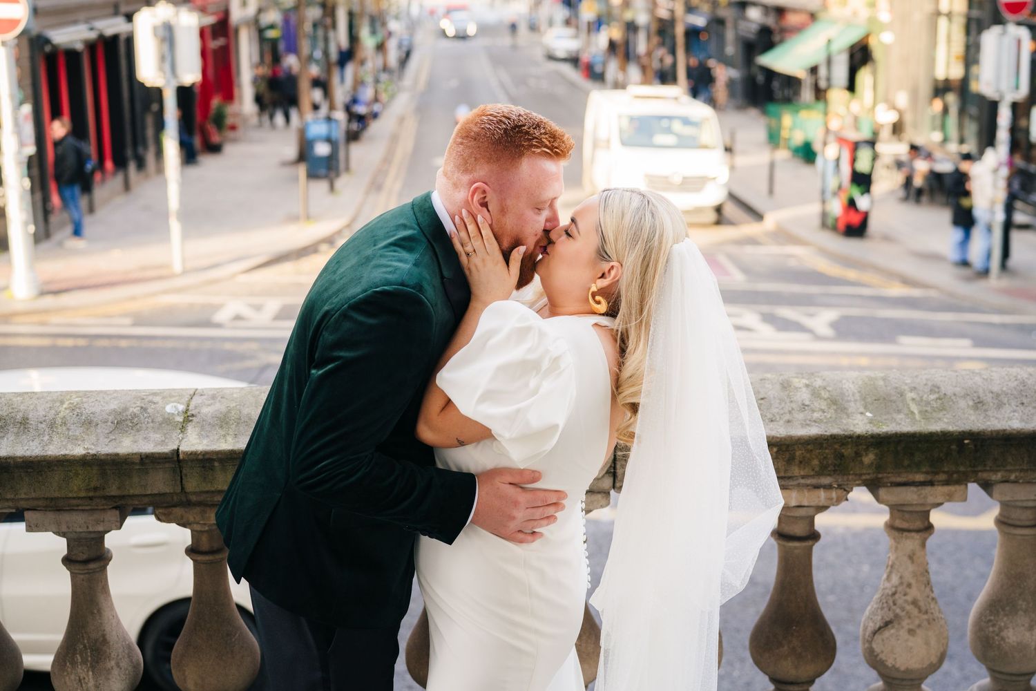 Newlyweds share intimate moments on a city street during their wedding day photoshoot. City Hall Dublin Photographer