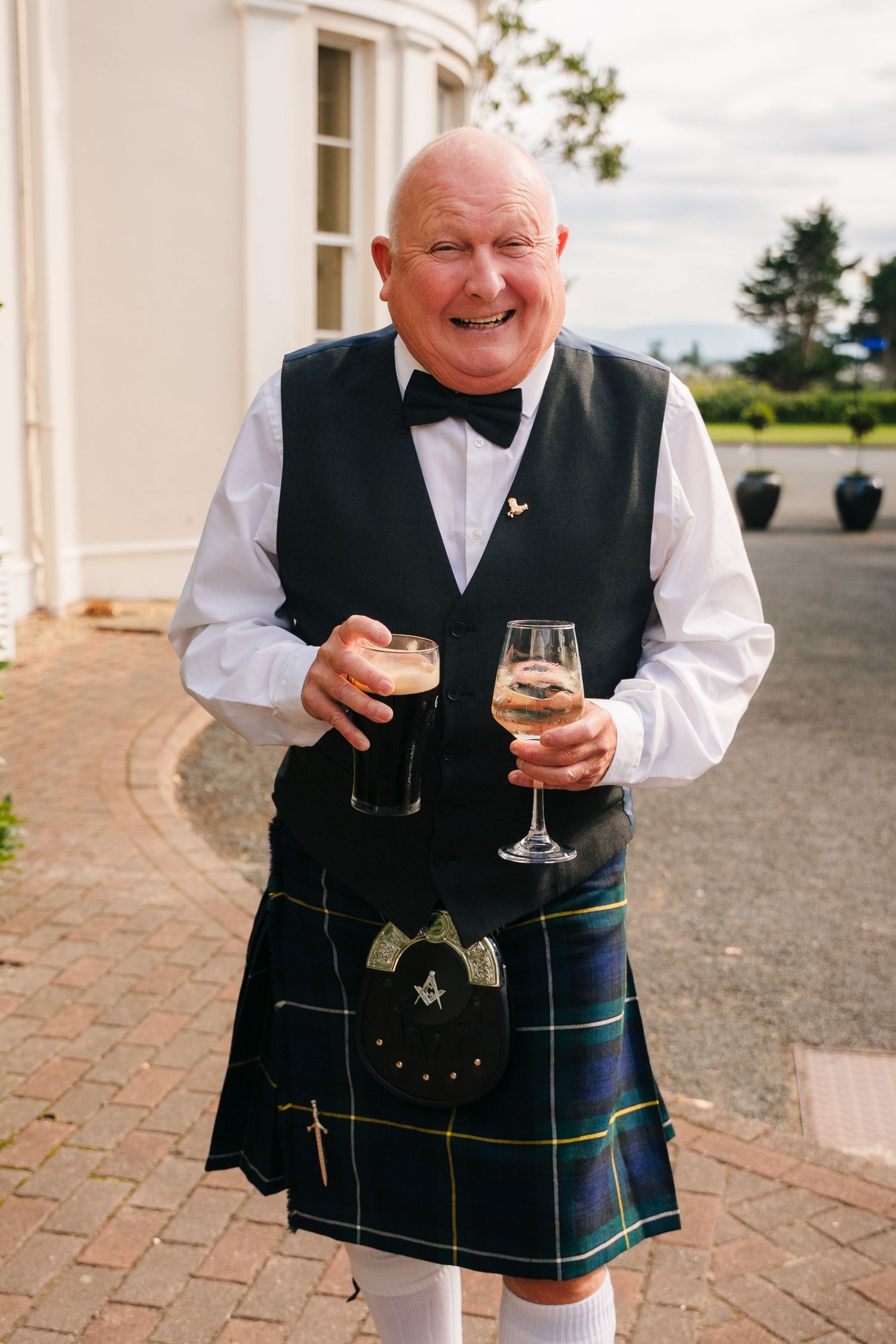 Four sequential photos show a person in traditional Scottish kilt attire holding and sipping from a wine glass outdoors. Wedding PHOTOGRAPHE