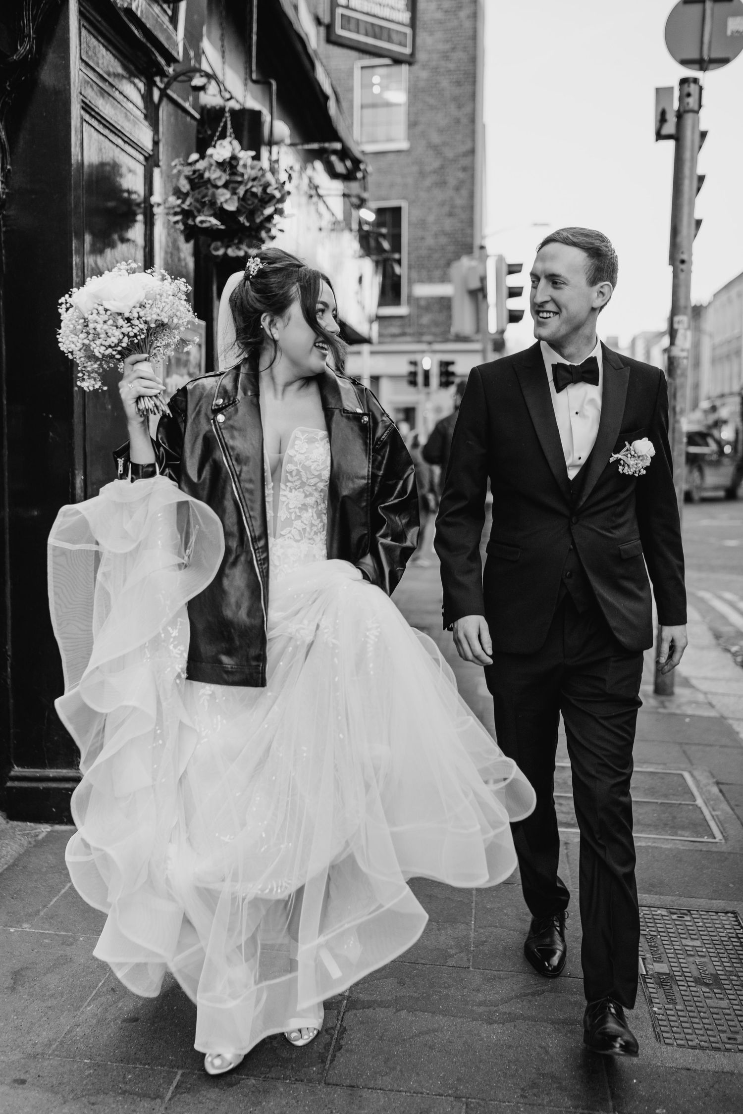 Wedding couple walking through city streets with bride's flowing white dress. Wedding PHOTOGRAPHER Dublin