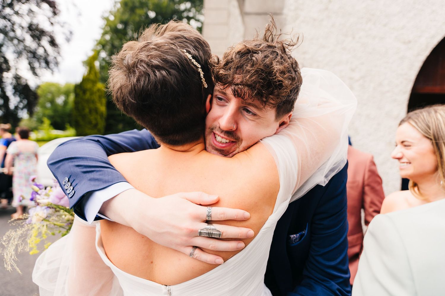Heartfelt embrace between guests during an emotional moment at an outdoor wedding celebration.Millhouse slane wedding photographer dublin