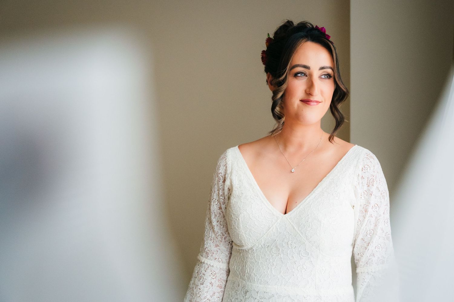 A bride wearing a long-sleeved lace dress poses in soft natural window light. Wedding Photography Trim Castle Ireland