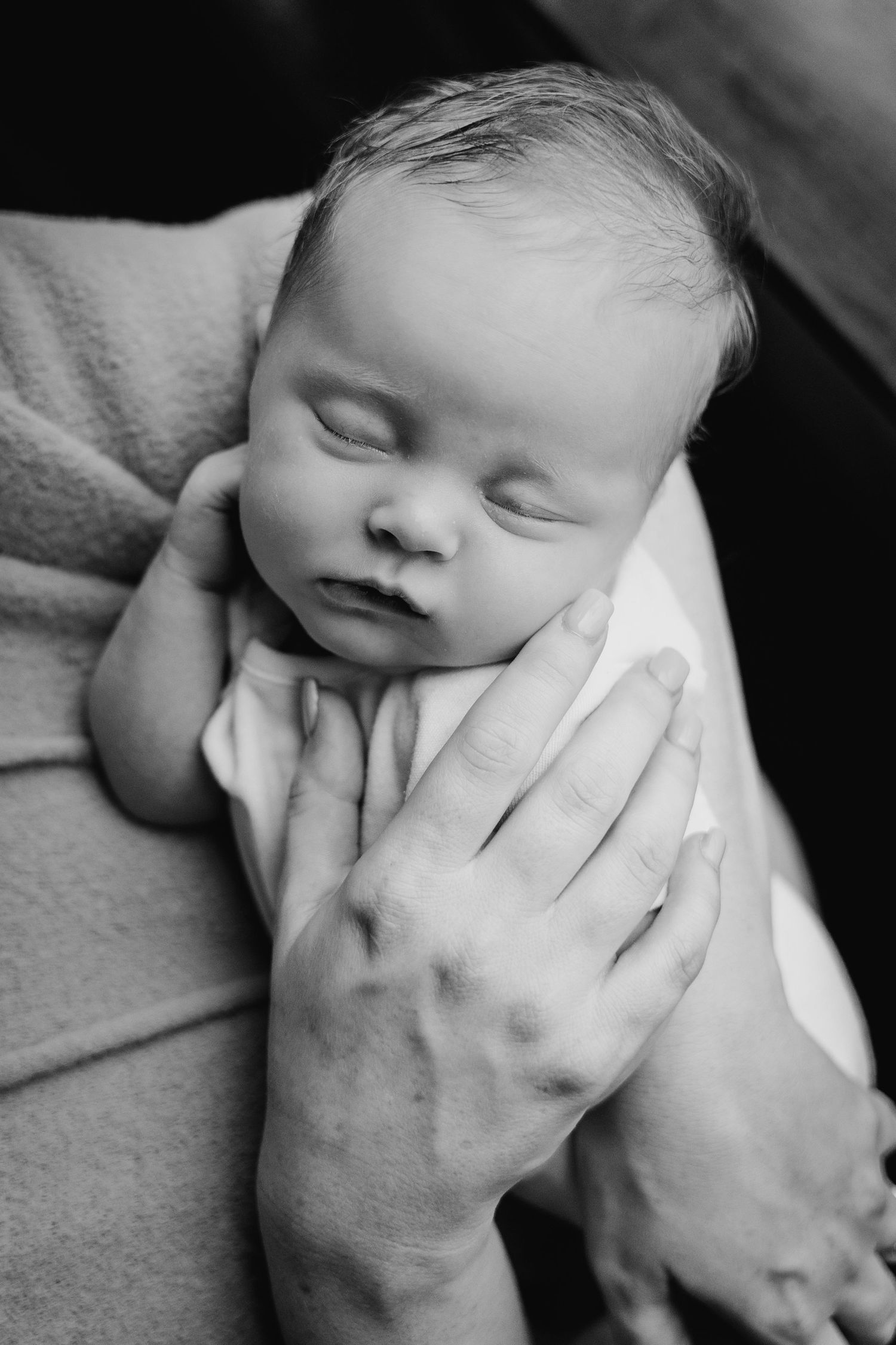 A black and white multi-panel photo showing a sleeping baby with a hand gently touching their cheek. Family PHOTOGRAPHER Dublin
