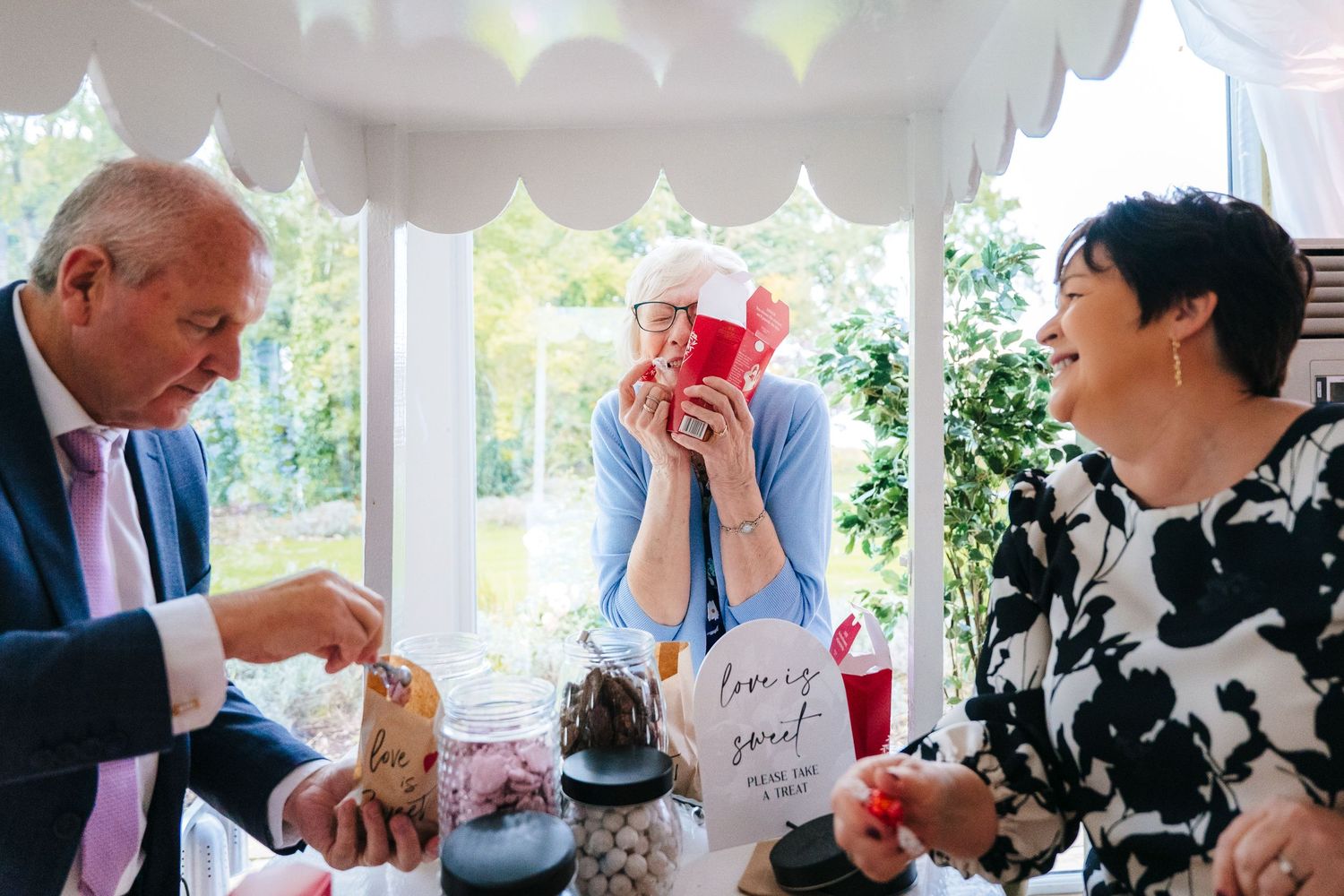 Group of people enjoying drinks and laughter at an elegant indoor gathering. Wedding Photographer Dublin Ireland