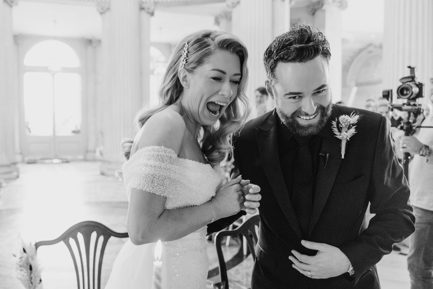 Candid moments of laughter and joy captured during wedding reception in elegant white interior.  city hall dublin wedding photos