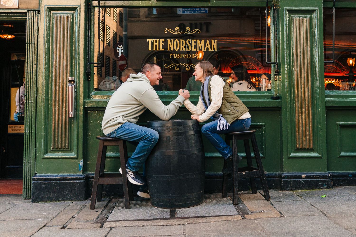A couple sits at bar stools outside The Norseman pub in Dublin's historic district. PHOTOGRAPHER Dublin ireland