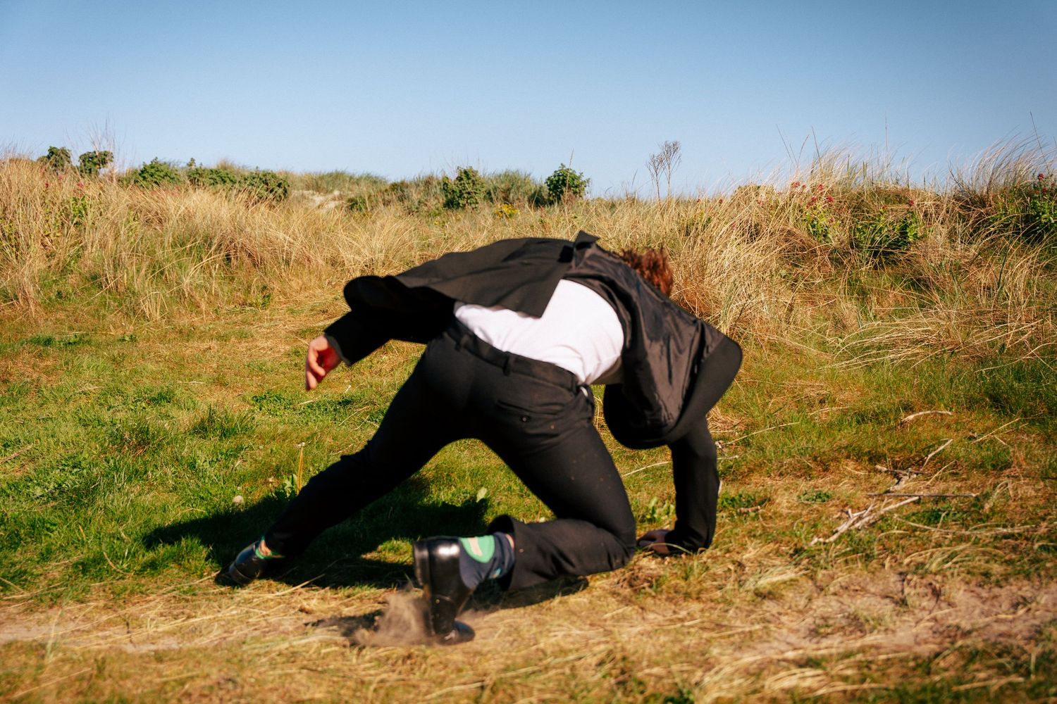 A figure shown rolling down a grassy hill in a sequence of stop-motion style photographs. PHOTOGRAPHER Dublin