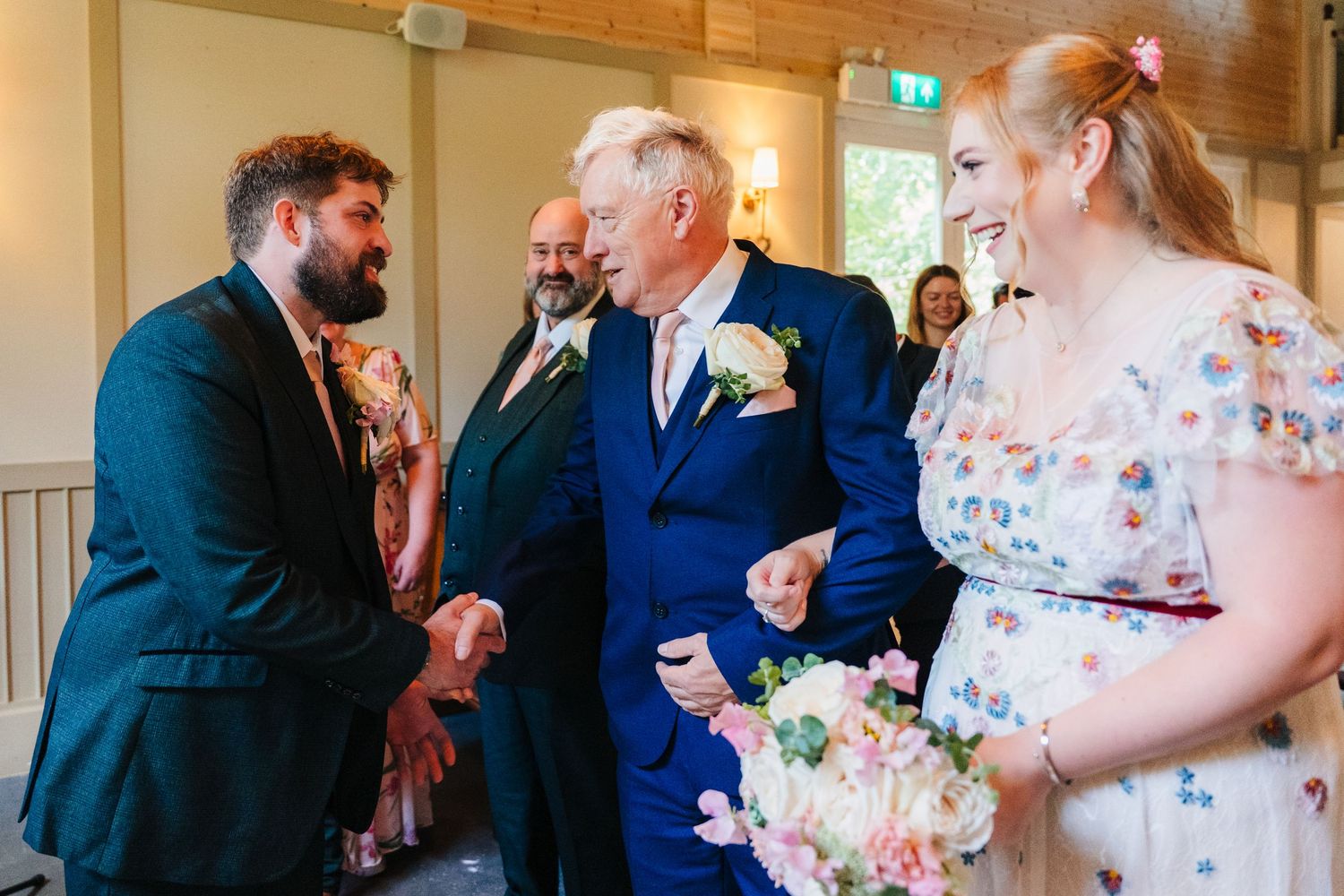 A formal gathering at a wedding with people in suits and dresses exchanging greetings. . Village Barn Tyrrellspass wedding photographer Irel